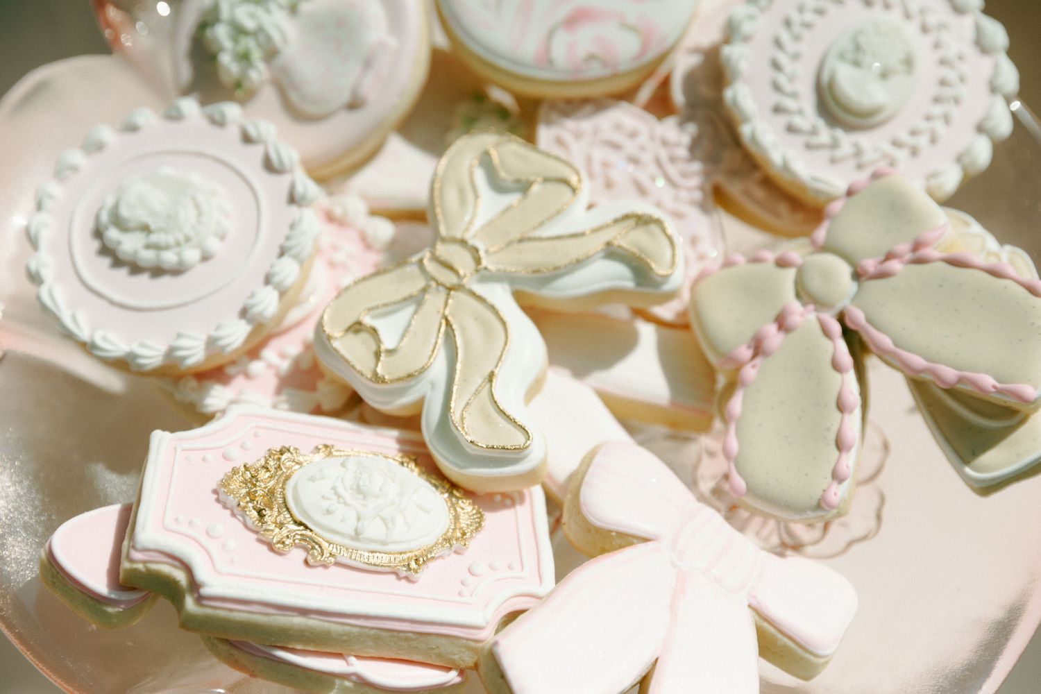 Elegant pastel tea party cookies decorated in mint green and pink with intricate cameo and lace details.