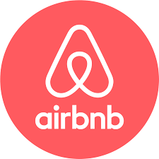 The Airbnb logo in white against a coral red circular background.