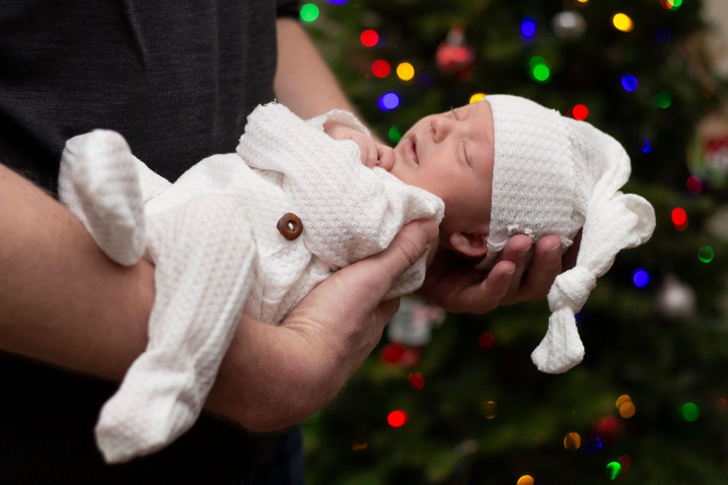 Lifestyle newborn photoshoot captured in a cozy home setting in Geneva, IL, featuring a peaceful baby and candid family