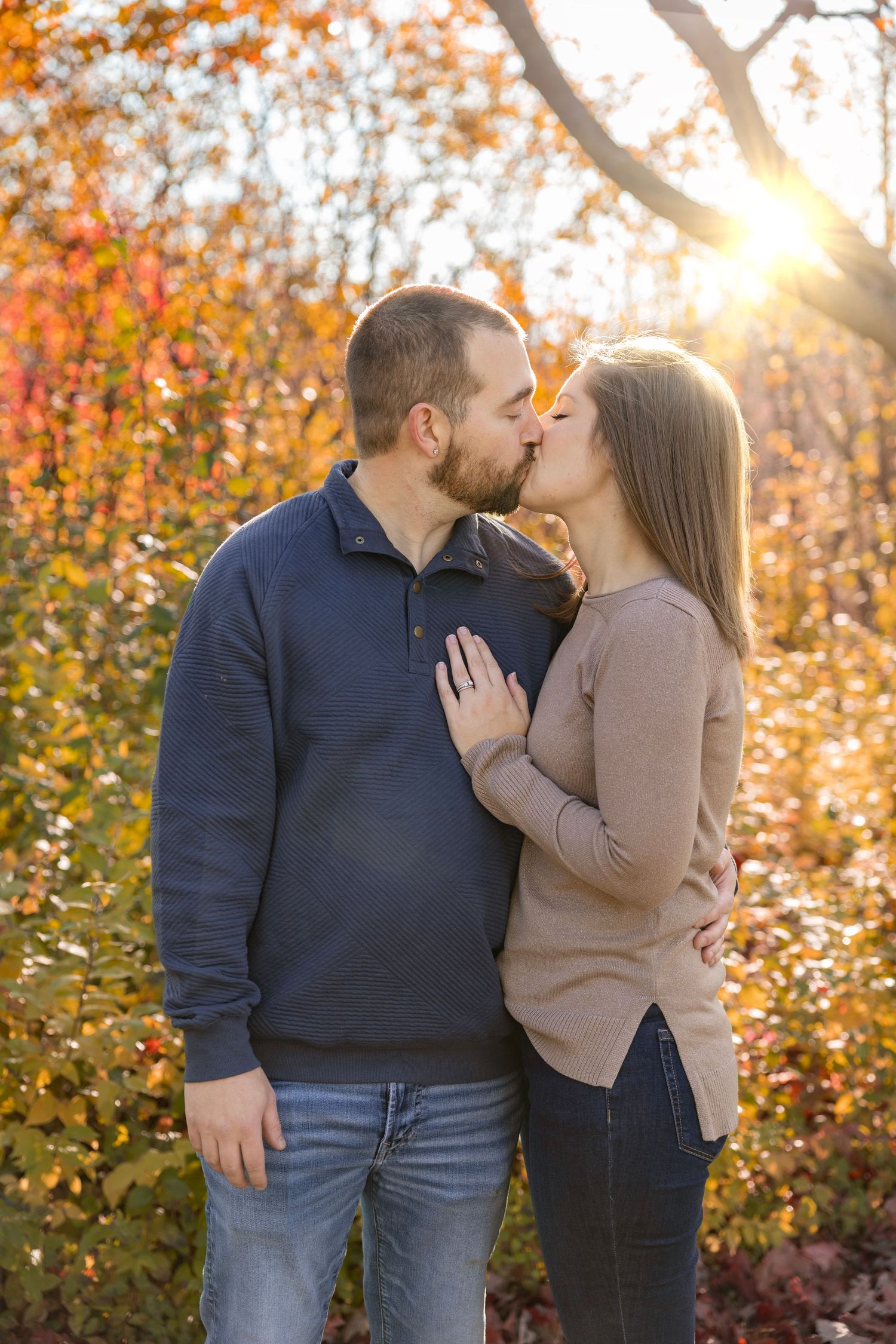 Romantic engagement session captured during golden hour in St. Charles, IL, featuring a couple embracing in warm sunligh