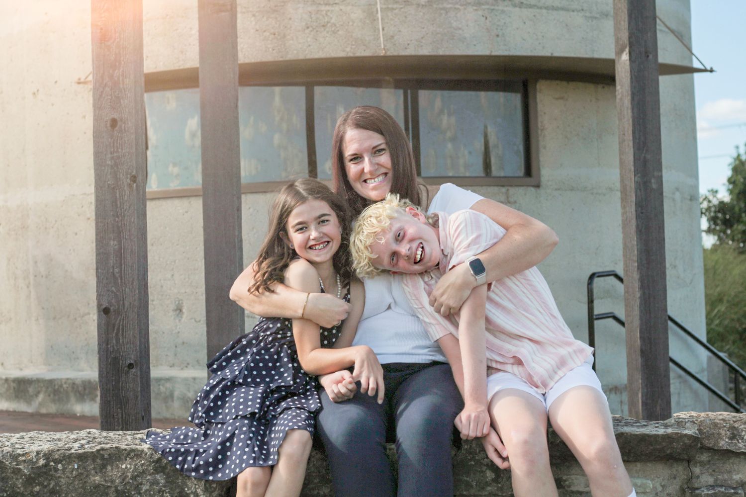 An aunt surrounded by her nieces and nephews, sharing hugs and laughter, radiating love and joy in a heartwarming family