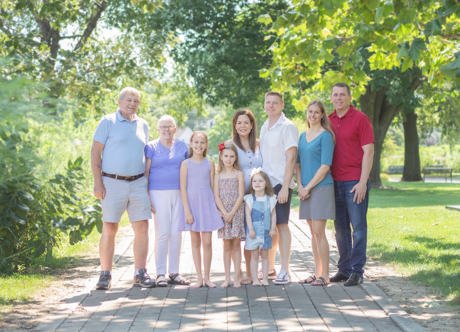 A large family session outdoors in Wheaton, IL, during spring, surrounded by lush green landscapes and vibrant blooming
