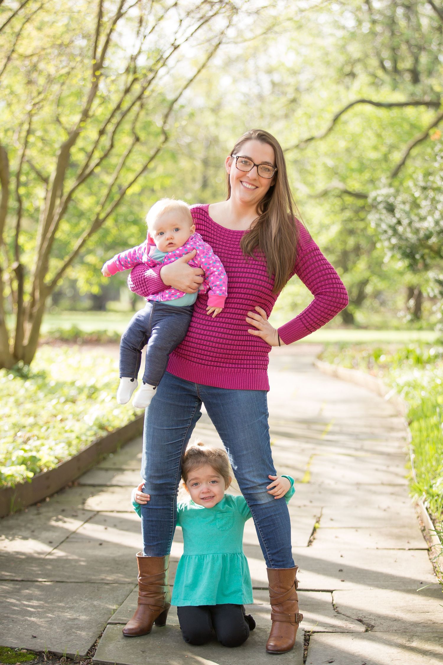 Photographer based in South Elgin, smiling warmly with arms lovingly holding her young children, capturing the essence o