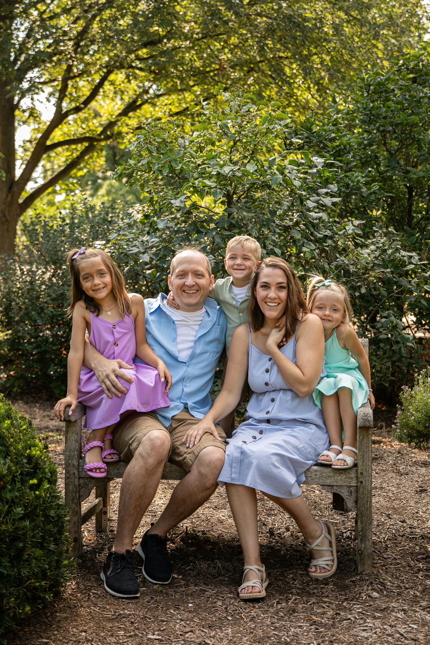 Beautiful family portrait captured in Lombard, IL at Lilacia Park, featuring parents and children in a natural outdoor s