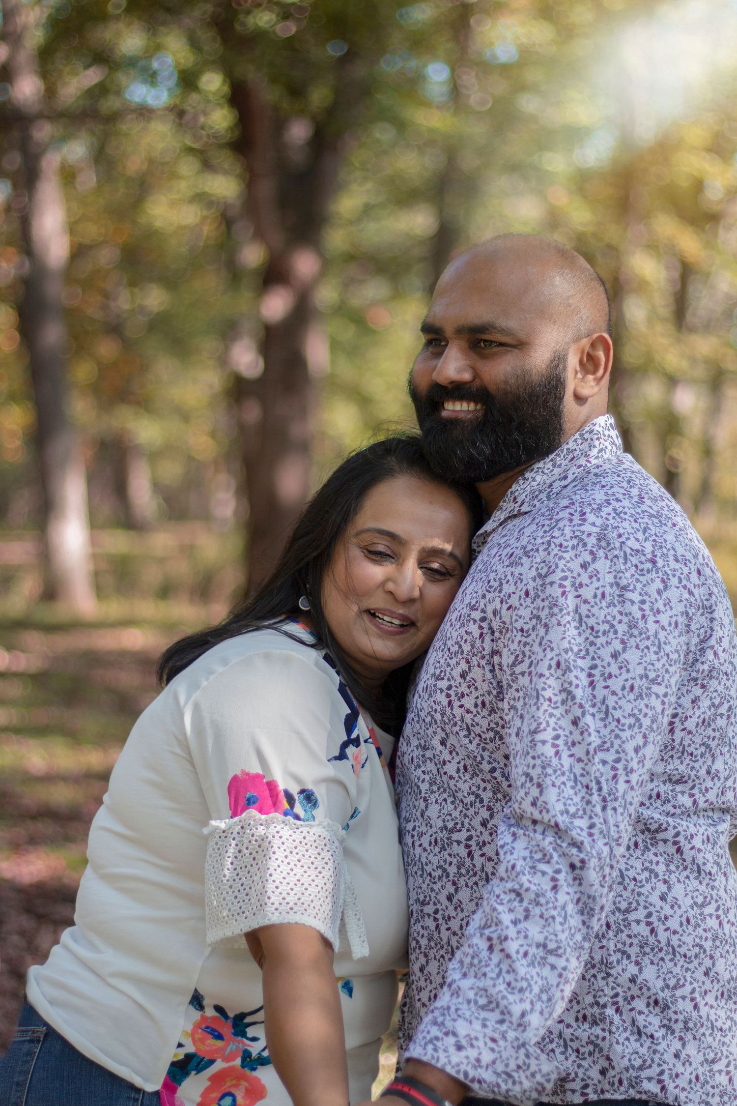 A tender married life photo of a loving couple, with her head gently rested on his chest, capturing a moment of intimacy