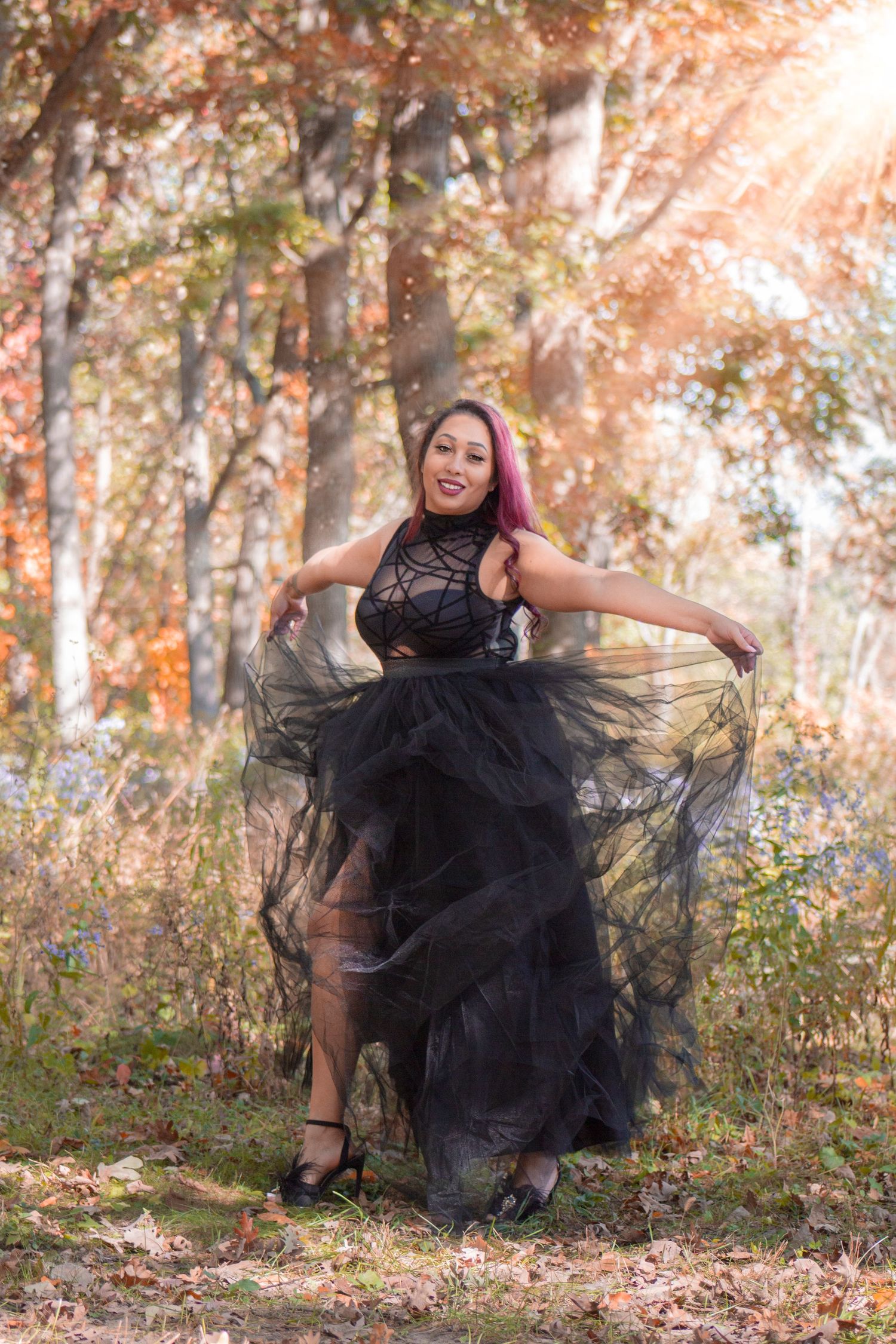 A captivating milestone photoshoot of a woman dressed in black, gracefully standing under the radiant rays of the sun, c