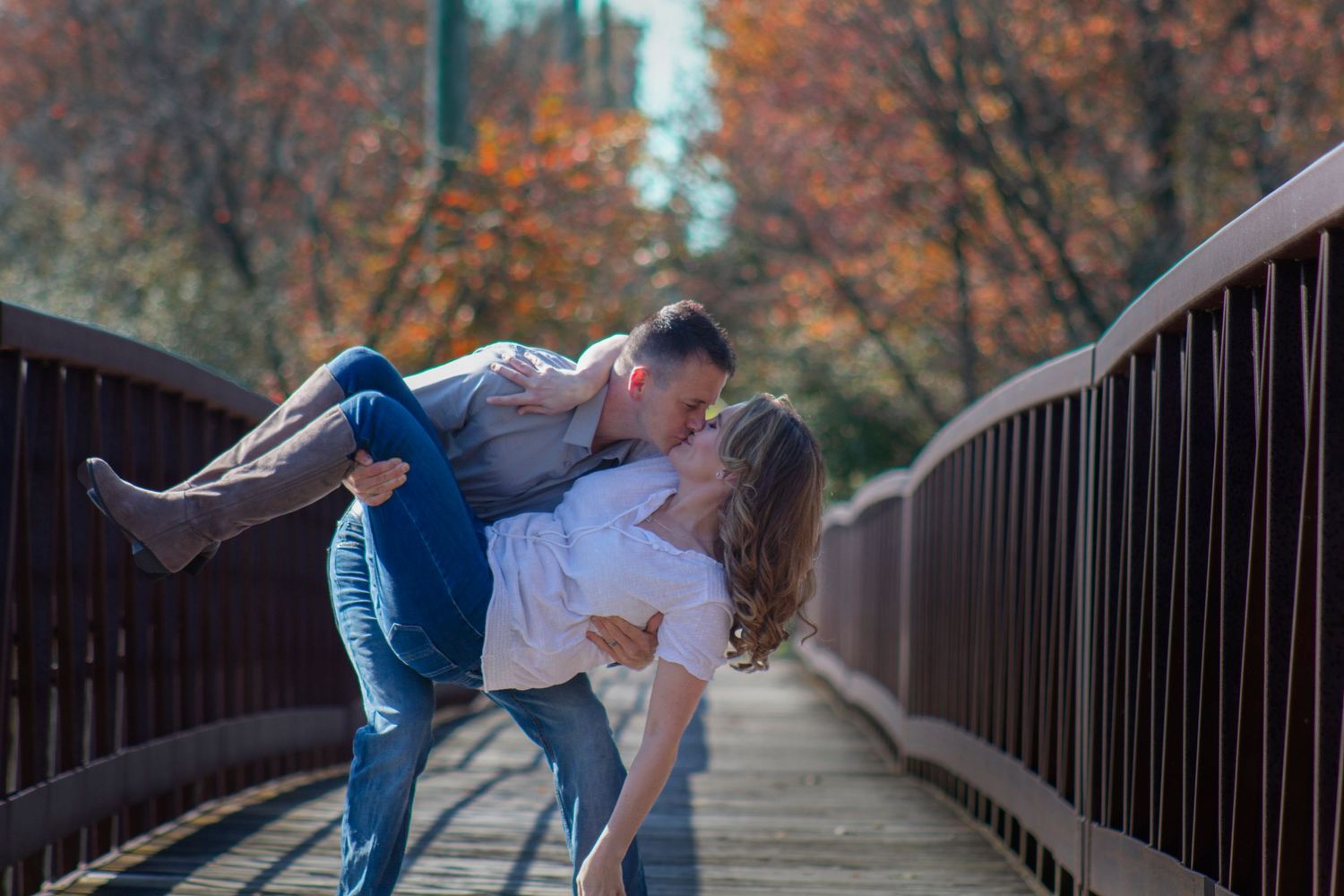 A romantic photo of a couple in love on a picturesque bridge in Elgin, IL, with the man gracefully dipping his wife, sur