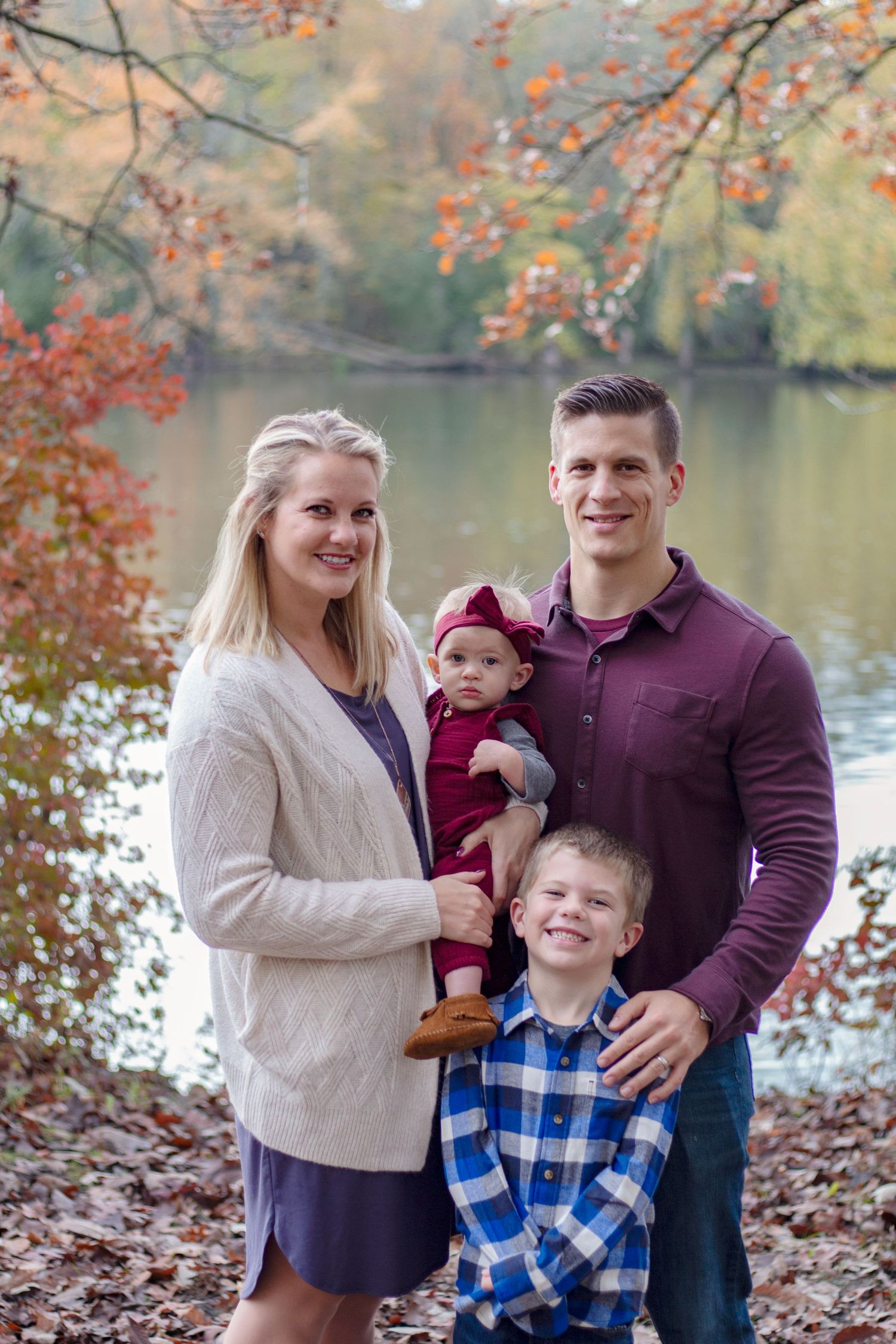 Small family session captured in Geneva, IL, featuring parents and a children enjoying a relaxed outdoor setting with wa