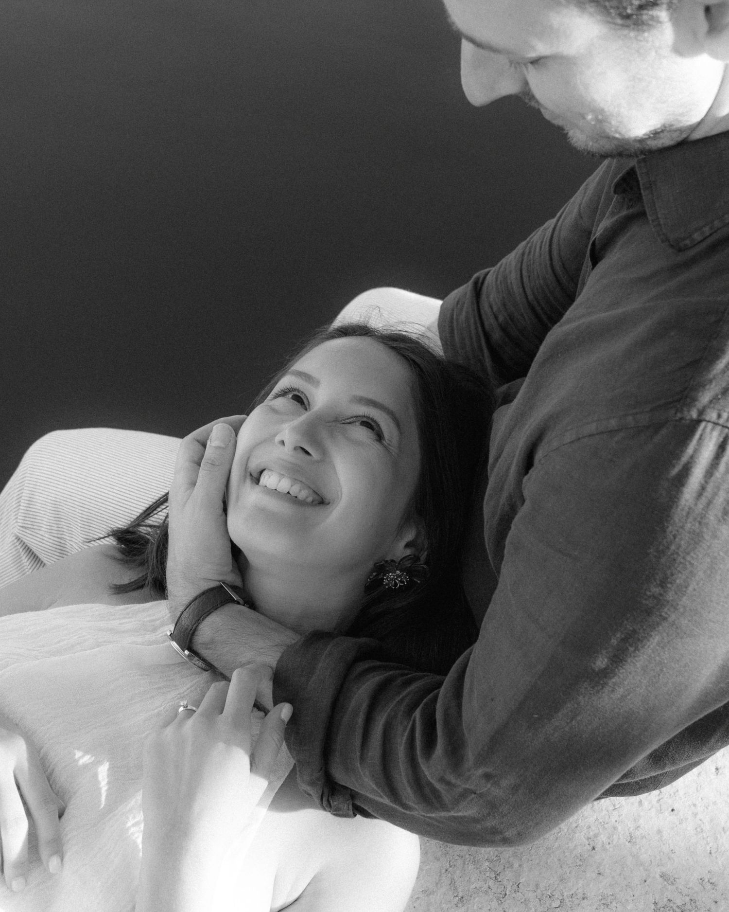 A black and white photo series showing someone lying down and looking upward with a peaceful expression.