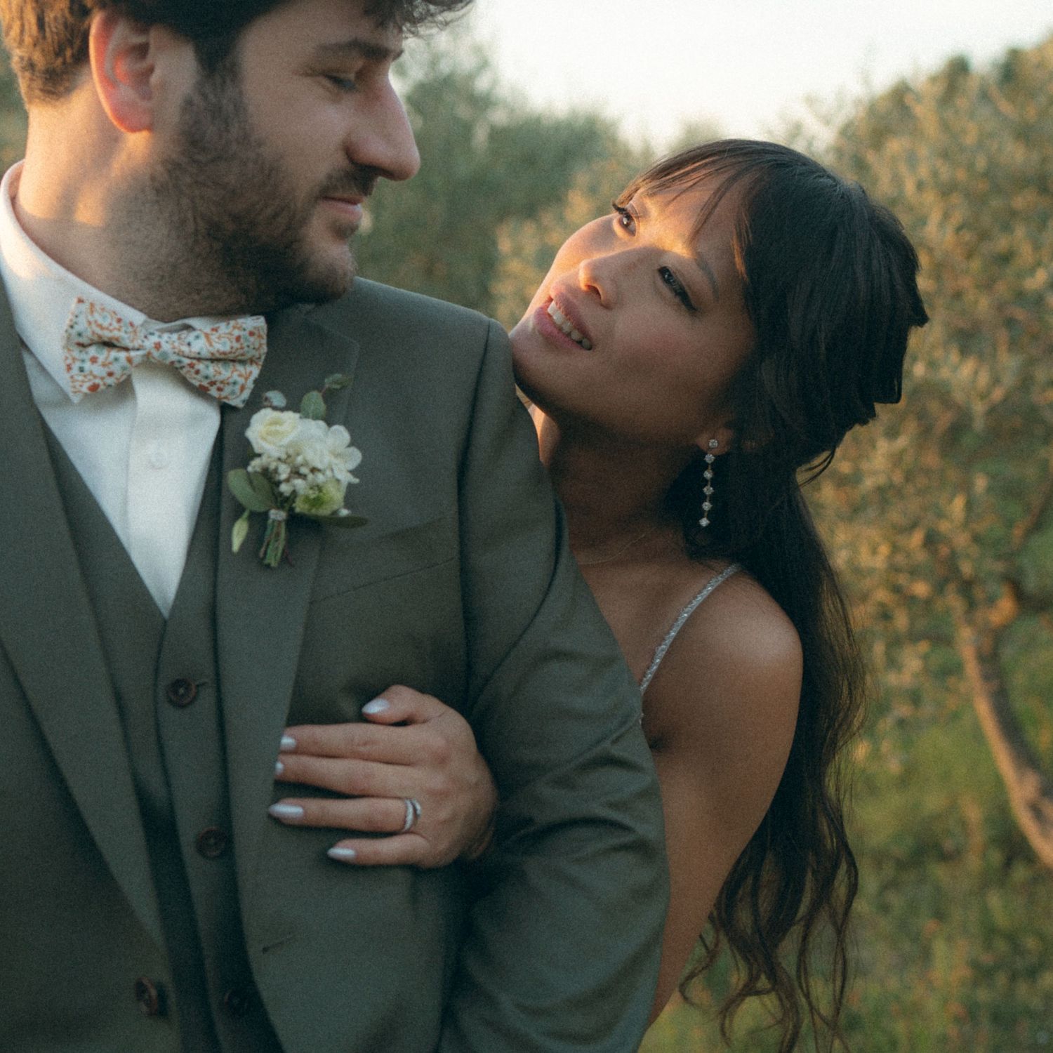 Romantic couple sharing intimate moments outdoors during golden hour wedding photoshoot in a natural setting.