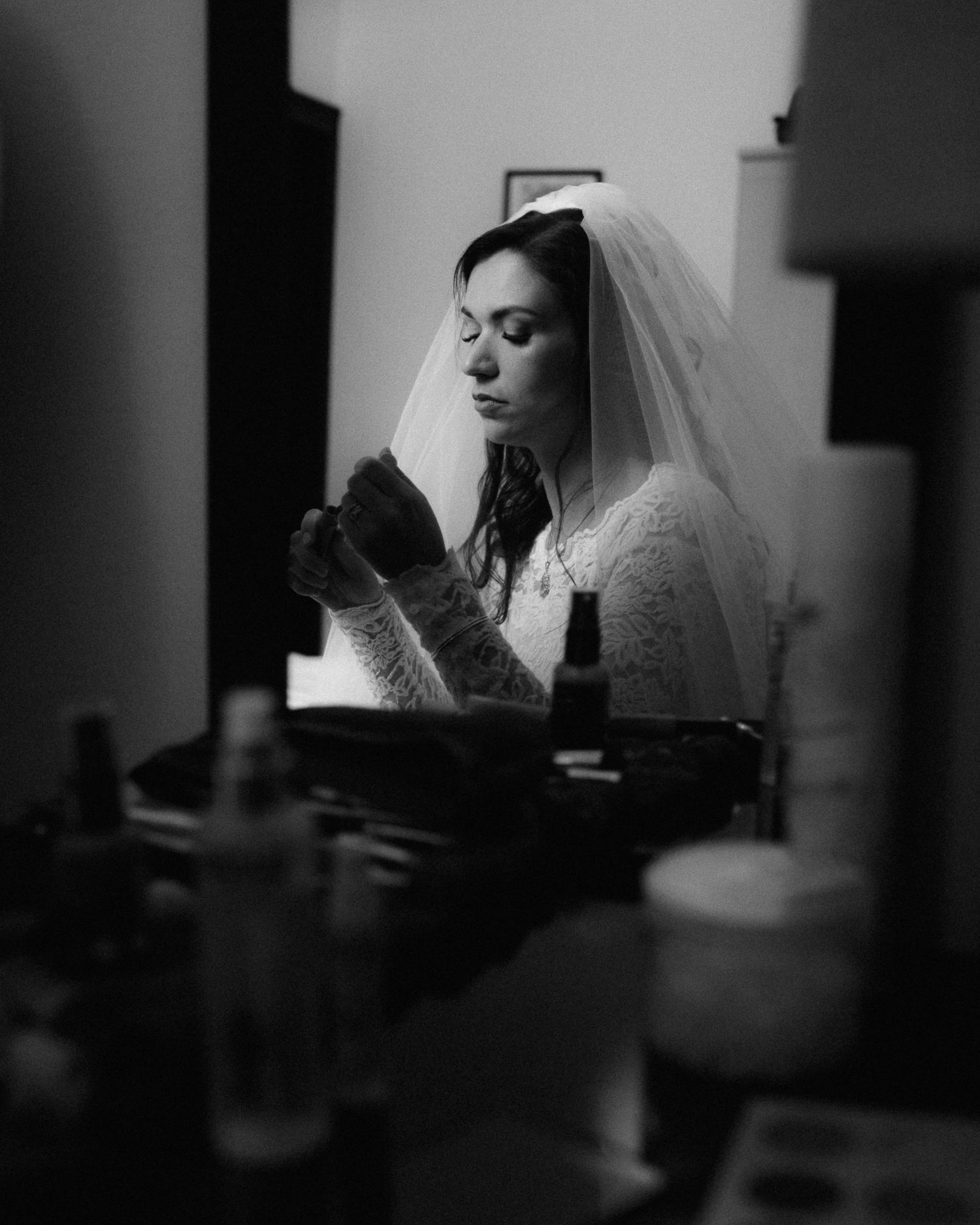 A dramatic black and white wedding portrait series showing a bride in profile with delicate veil details.