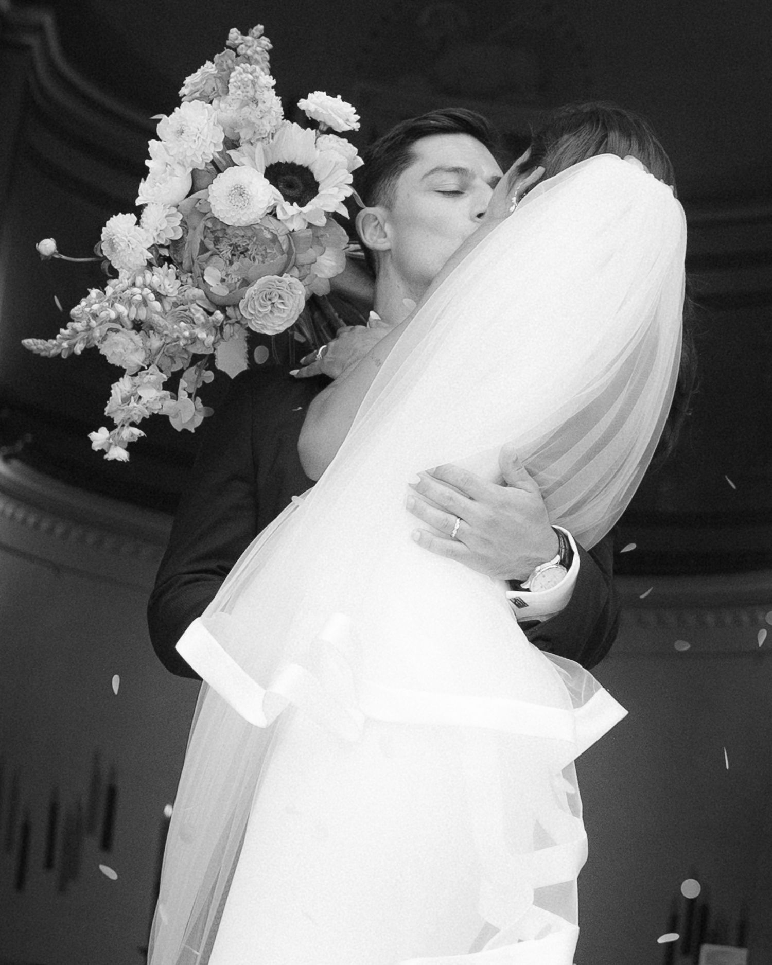 Black and white wedding photos showing romantic close-up dance moments with flowing white veil and floral decorations.
