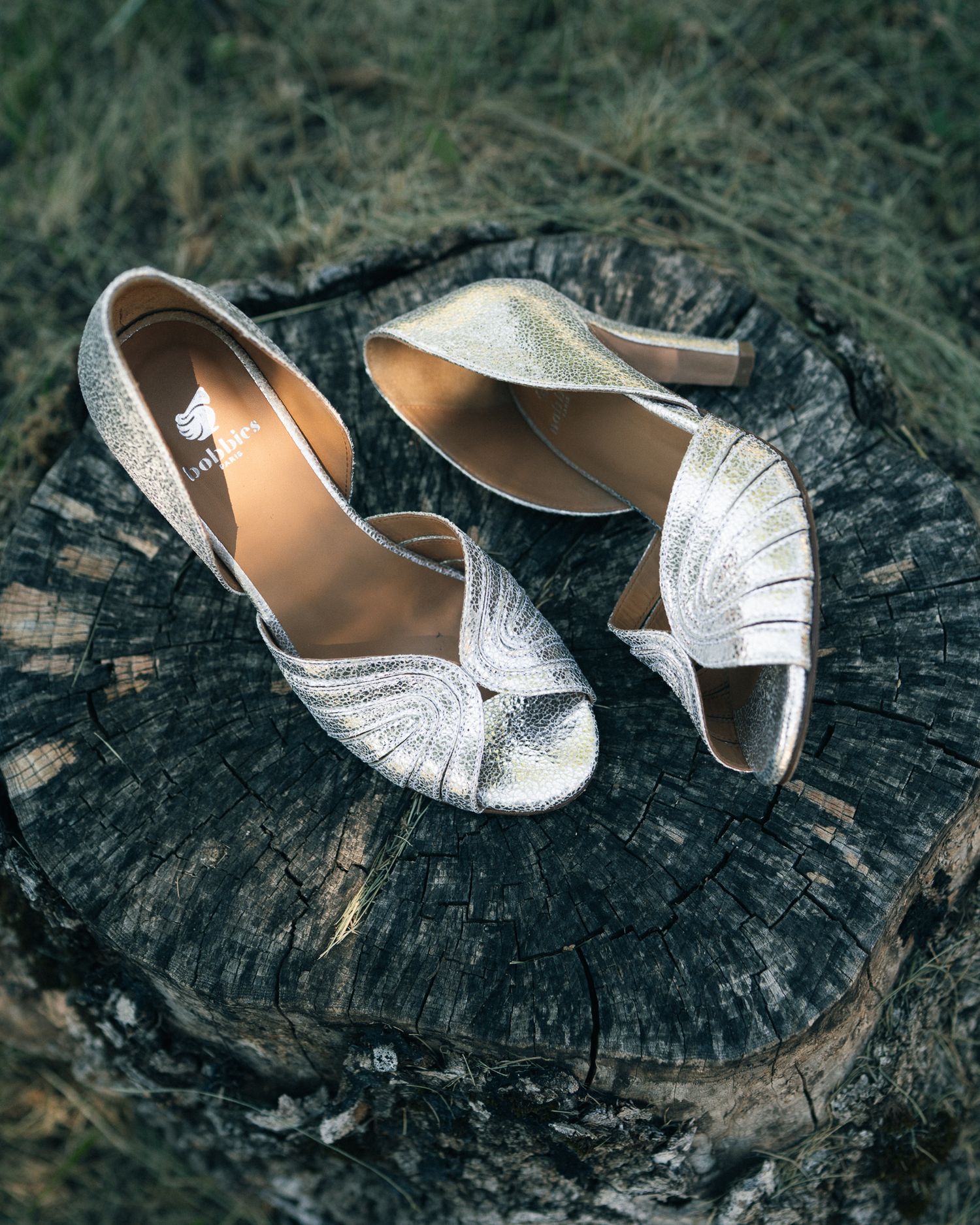 Silver glitter wedding shoes with delicate straps displayed on weathered wood surface in multiple angles.