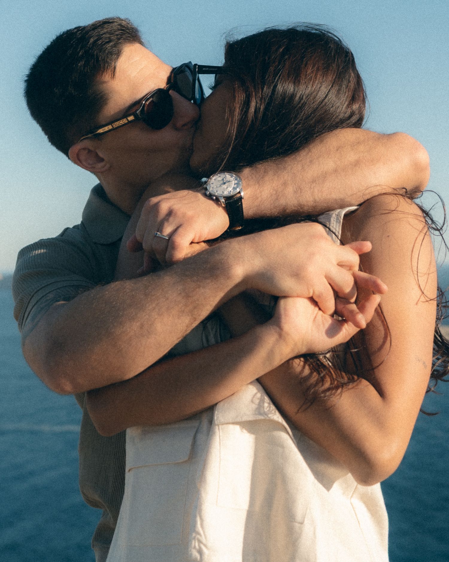 A series of four intimate silhouettes embracing against a blue ocean background.