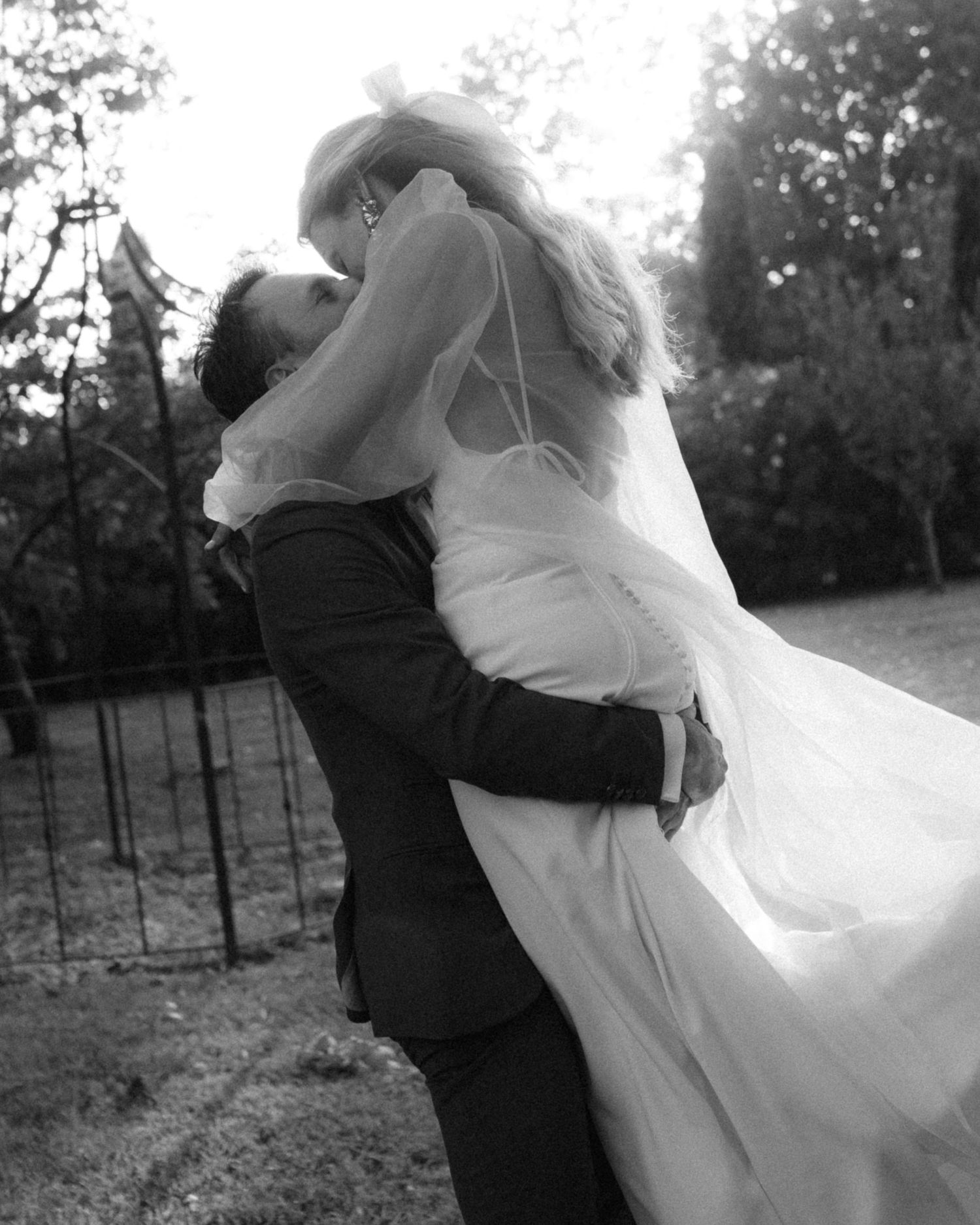 A romantic black and white wedding photo sequence shows a couple embracing and spinning in an outdoor vineyard setting.