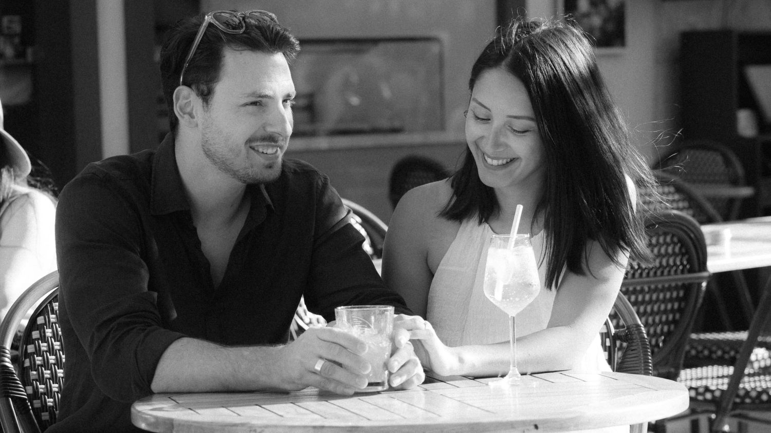 A black and white collage of people sitting at tables and desks in candid moments.