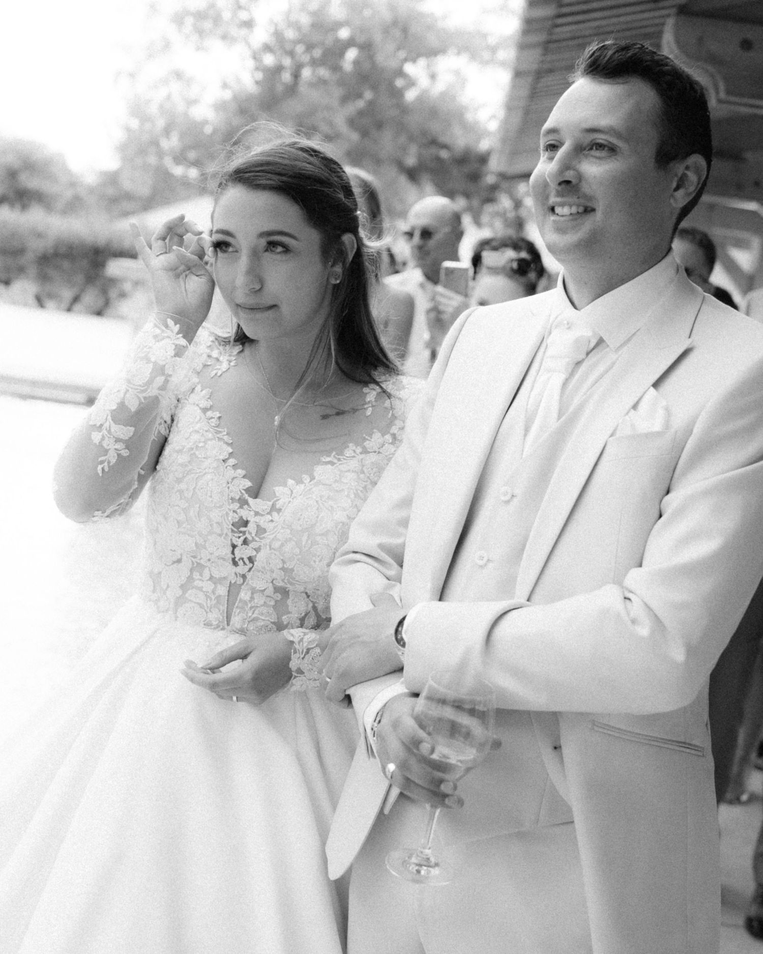 A black and white wedding photo series showing a couple in traditional attire embracing outdoors.