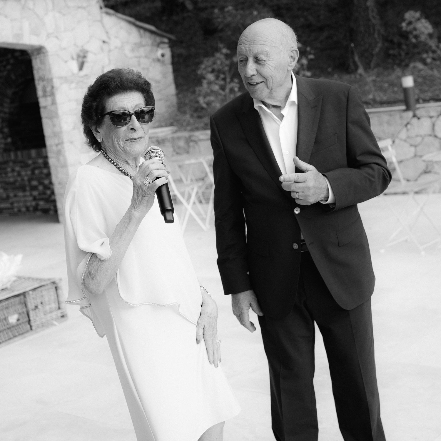 A series of black and white wedding photos showing candid moments between a couple in formal attire.