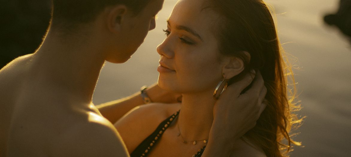 A person in profile view is silhouetted against a warm sunset background creating a dramatic atmospheric portrait.