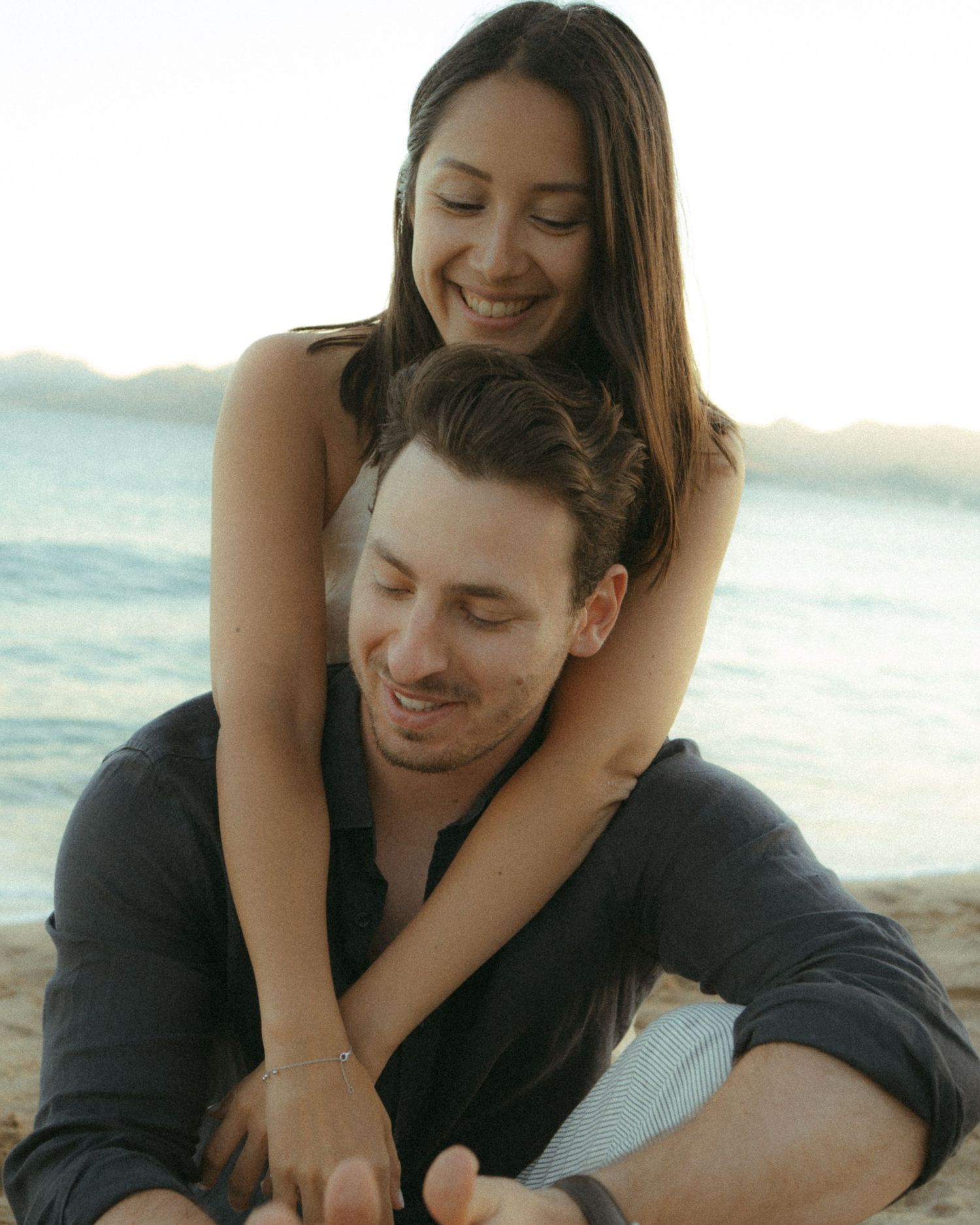 A couple shares tender moments together on the beach at sunset in a series of romantic photographs.