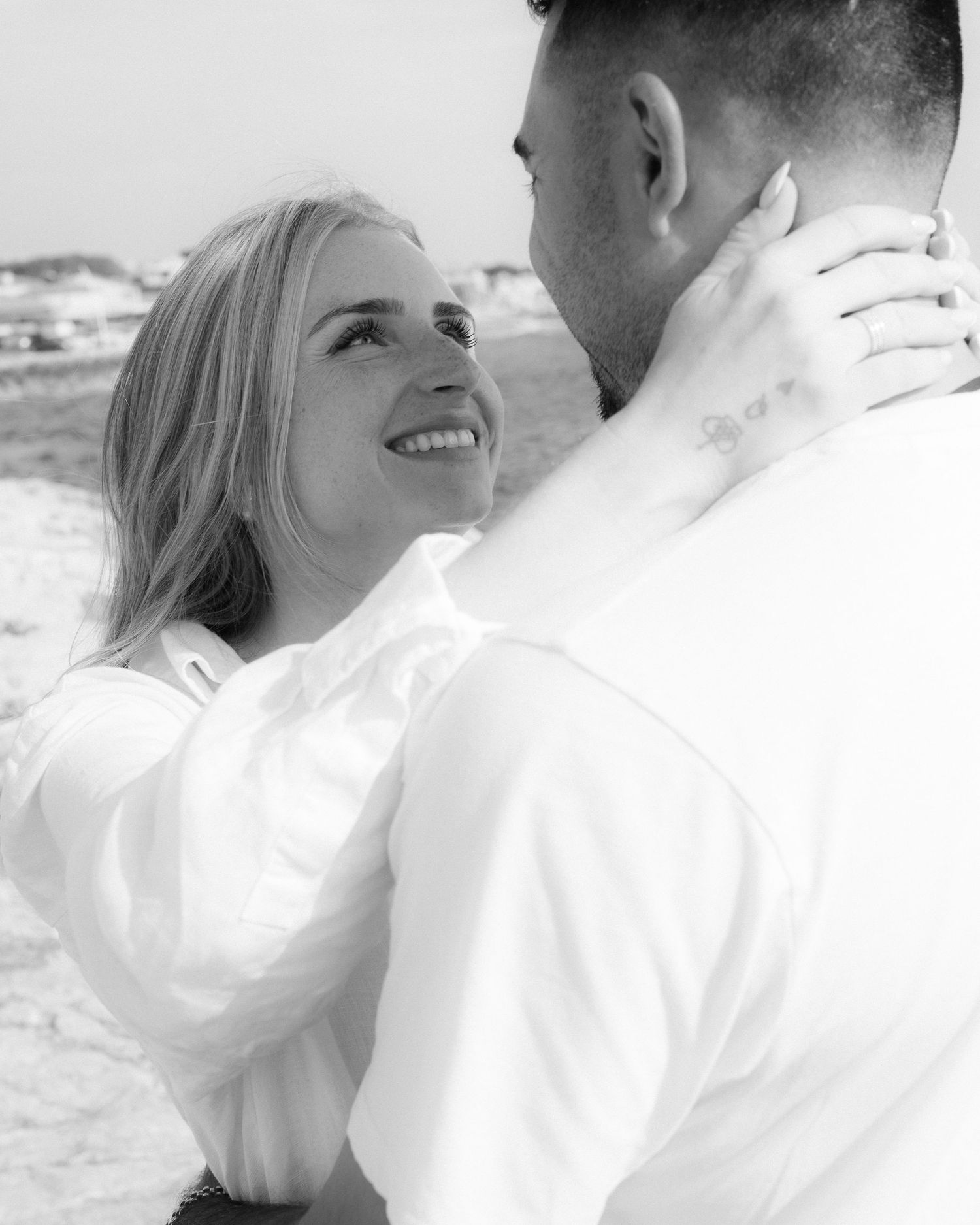 Black and white romantic portrait of a couple embracing outdoors.