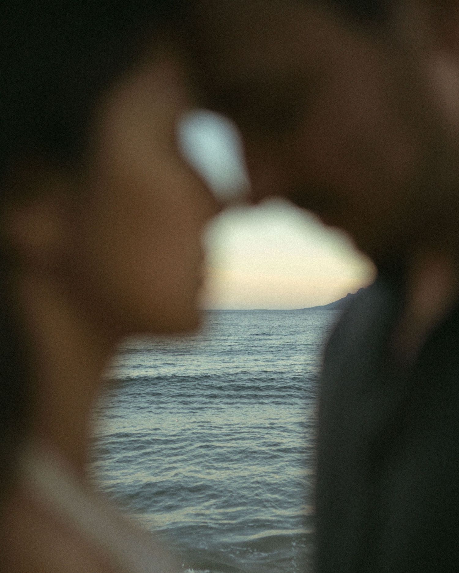 A sequence of blurry images transitions from dark tones to a view of rippling ocean waters at dusk.