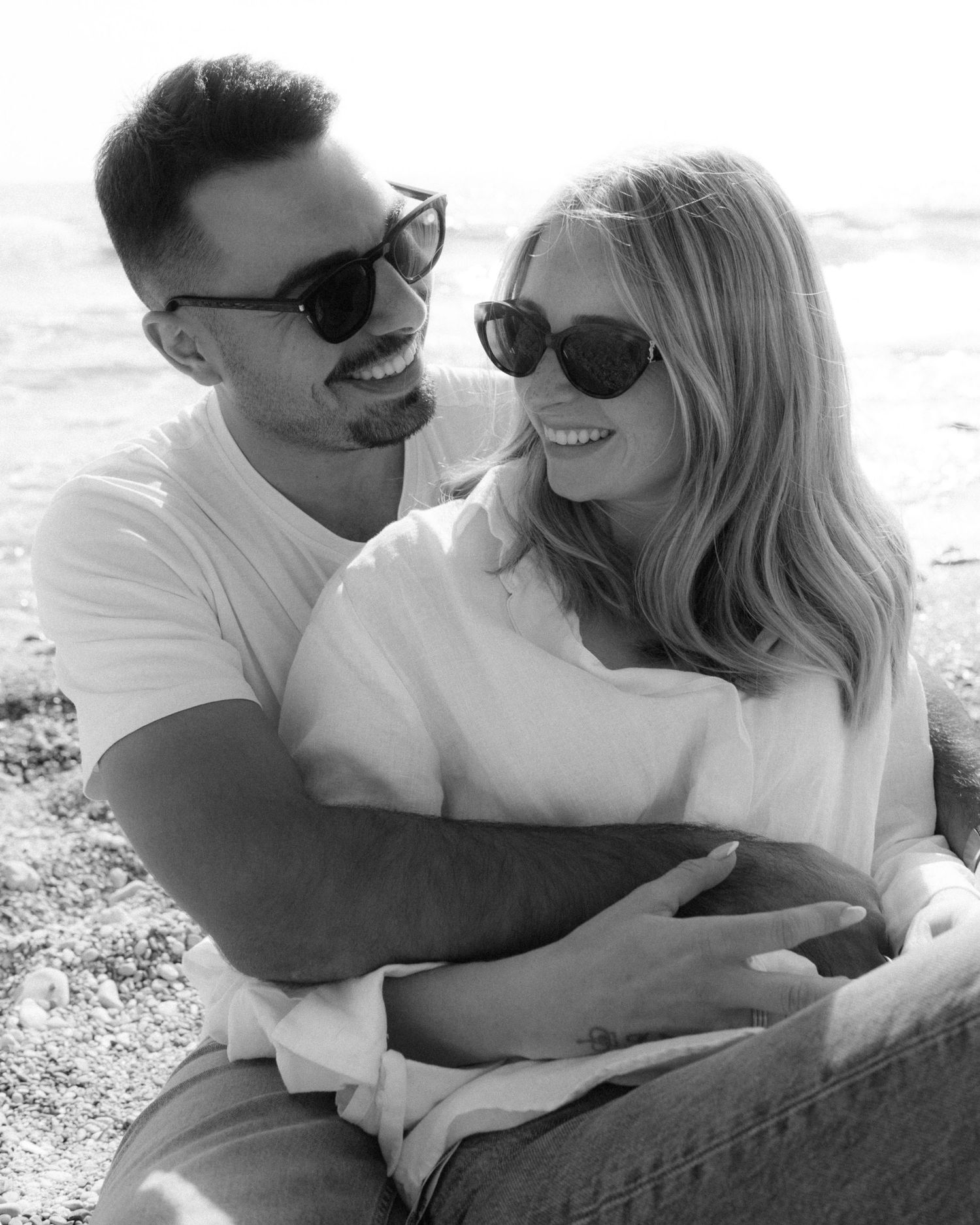 A black and white photo series shows a couple in white shirts sharing intimate moments while lying down outdoors.