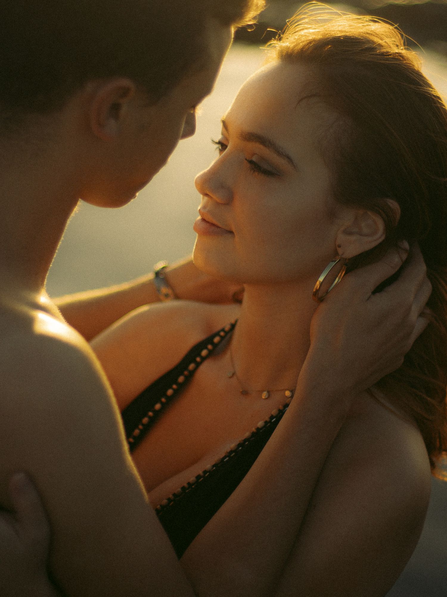 A romantic silhouette of a couple in golden sunlight sharing an intimate moment in a series of close-up shots.