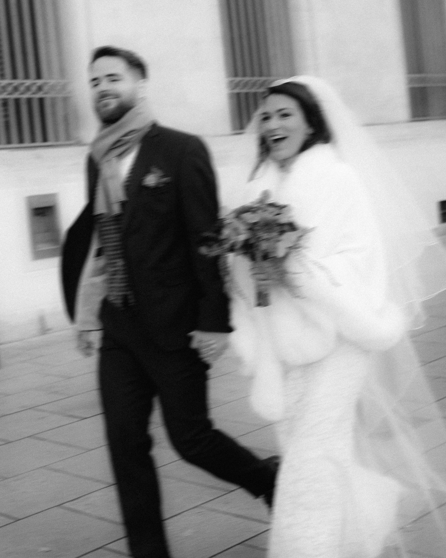 A black and white photo sequence shows a couple in wedding attire playfully interacting outside a building.