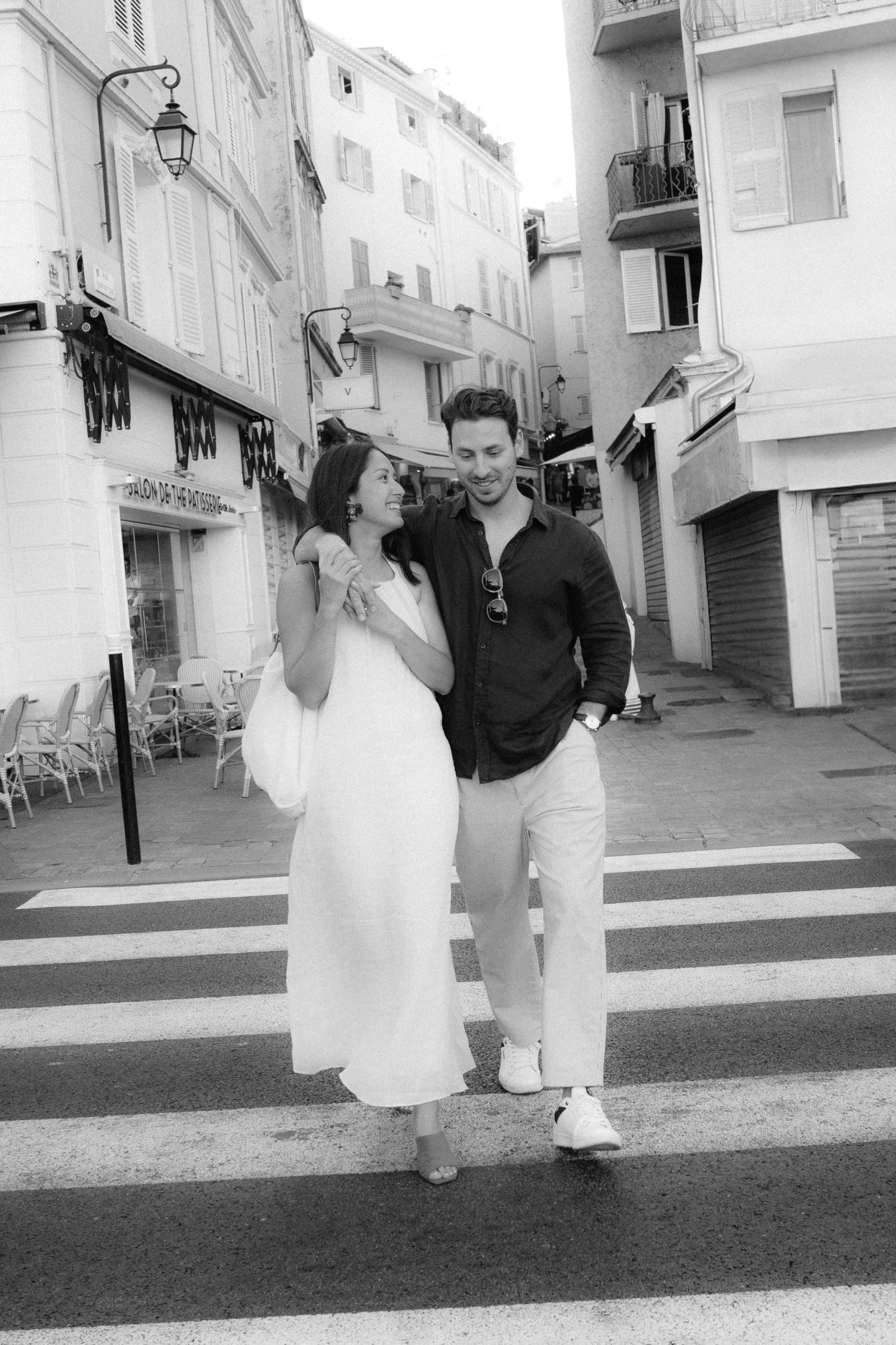 A series of black and white photos showing a couple walking down a Mediterranean-style street.
