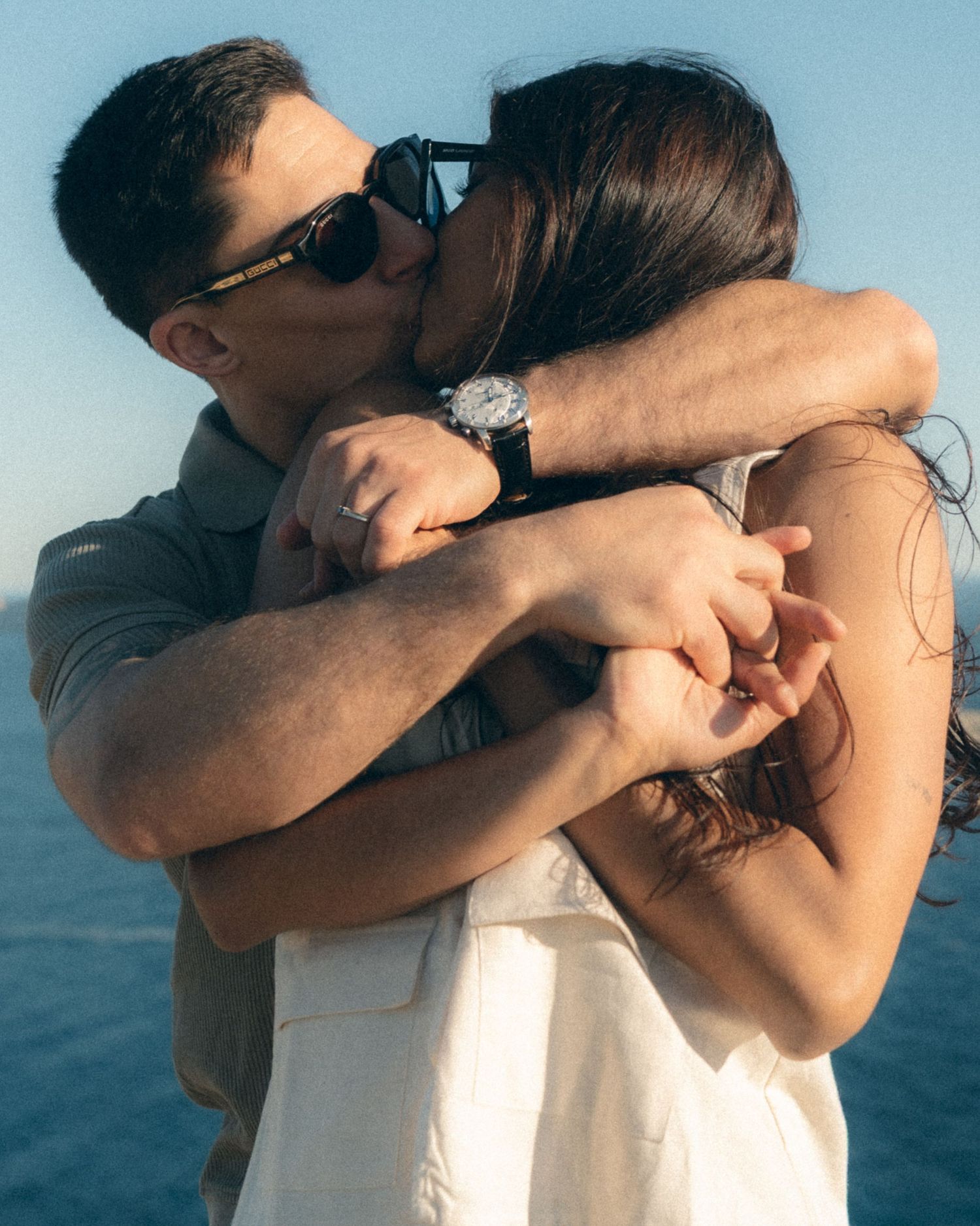 A series of four intimate photos showing a couple embracing against a blue sky background.