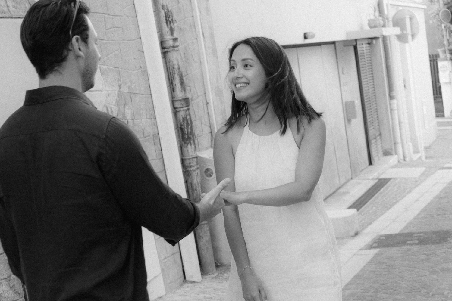 Black and white photo collage showing a couple walking and dancing together in a romantic sequence on a city street.