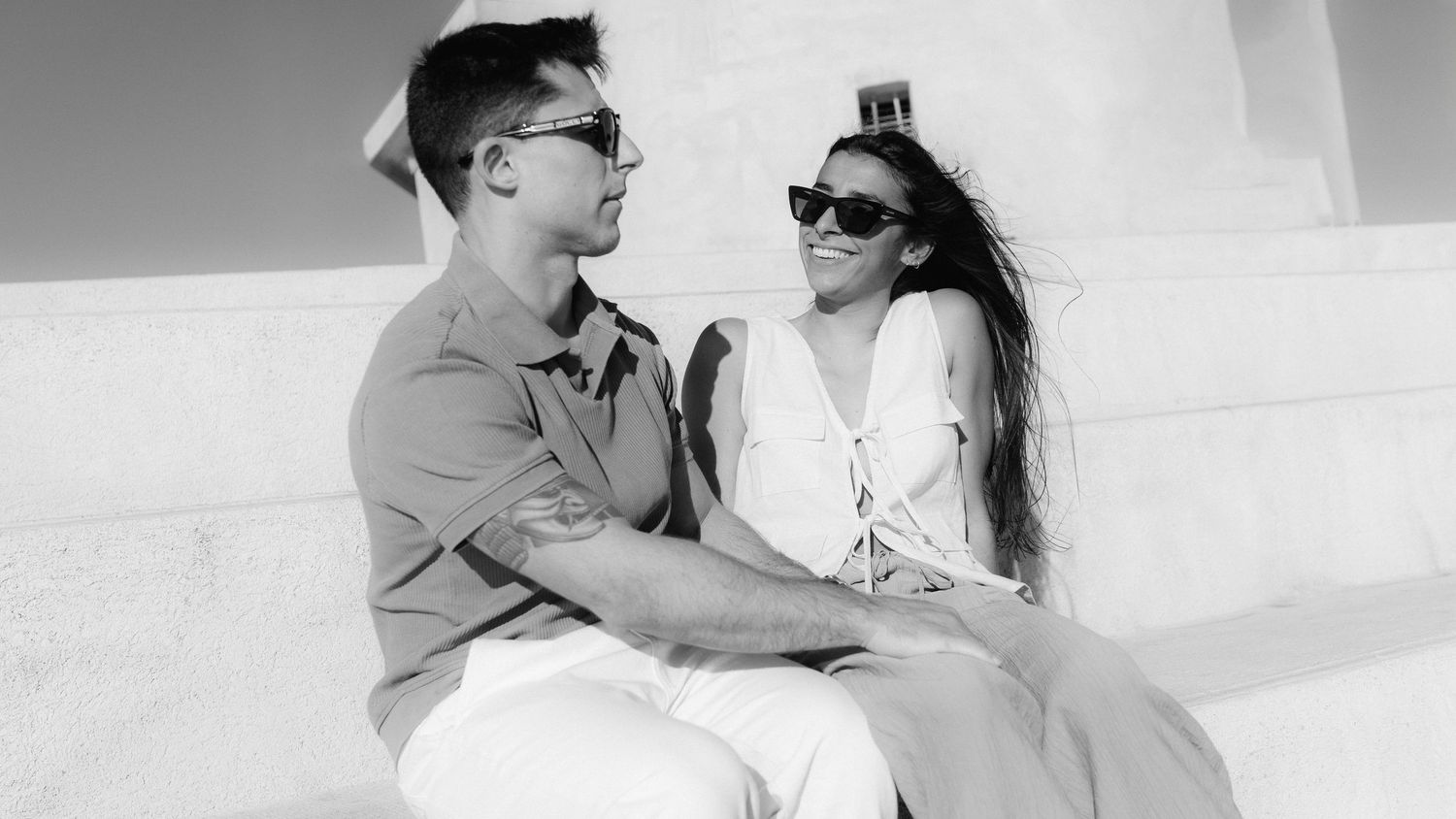 A couple shares tender moments in black and white photographs showing affection and romance.