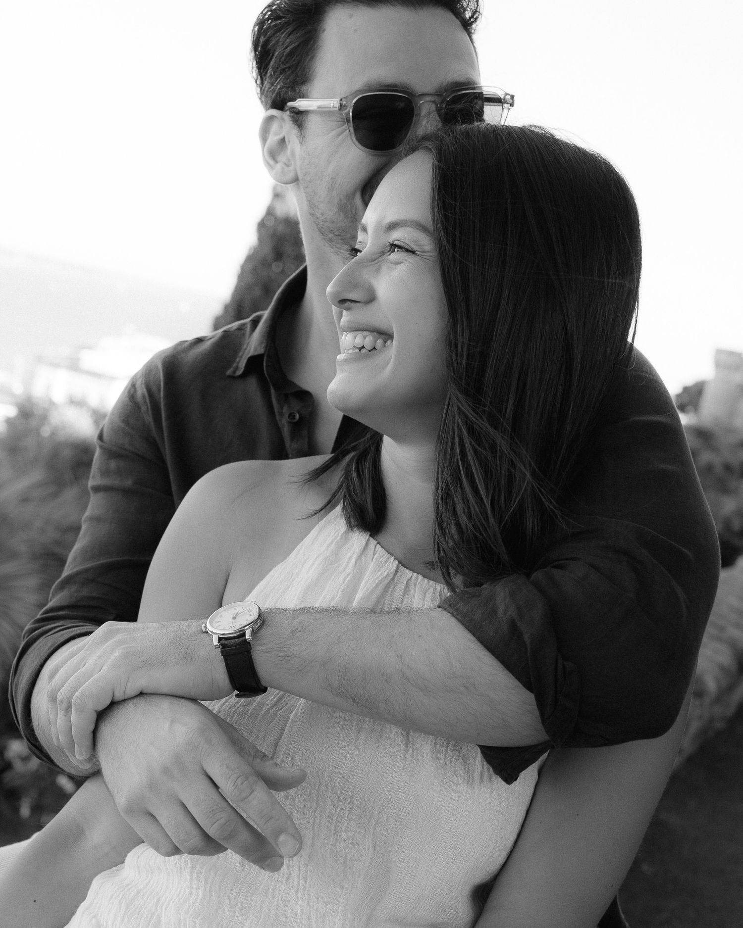 Black and white candid photos showing intimate embraces and laughter between a couple.