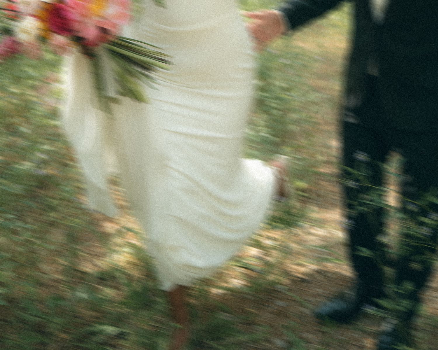 Artistic close-up of flowing white fabric and flowers against natural foliage.