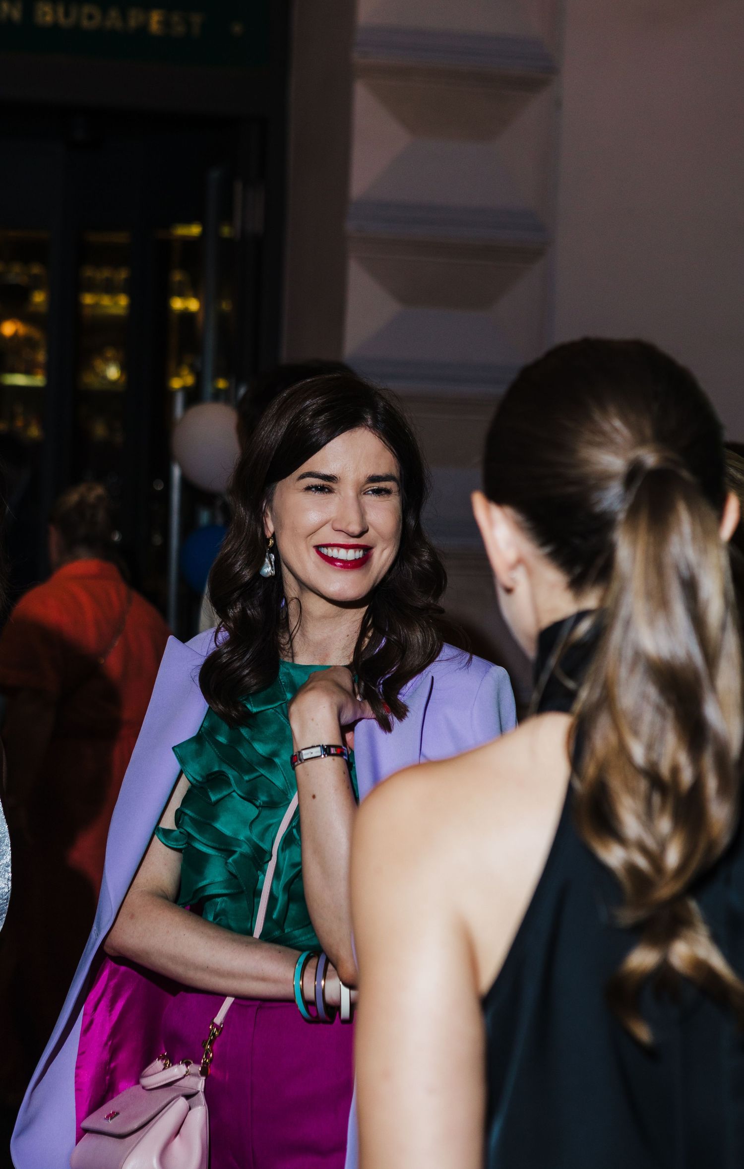 Two people engaged in conversation at an elegant evening event.