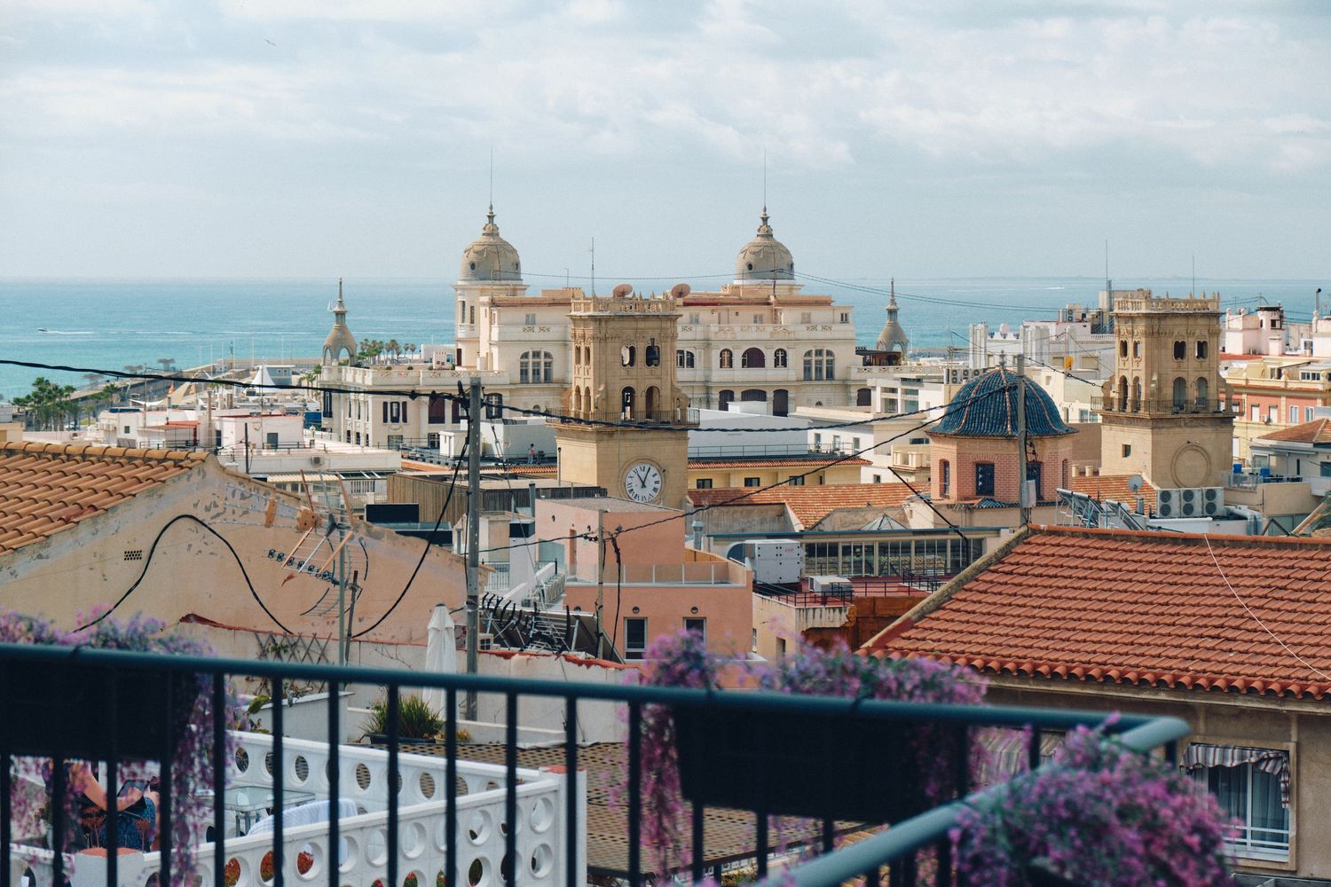 Historic Mediterranean cityscape with ornate domed buildings and terracotta rooftops overlooking the sea.