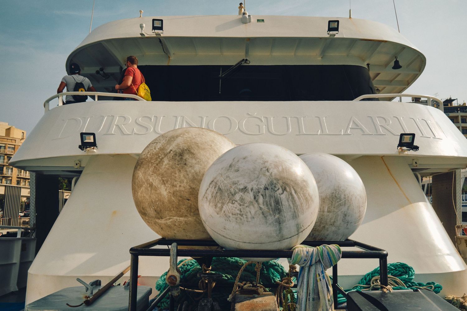 Large decorative spheres displayed on top of a boat deck in Malta's harbor.