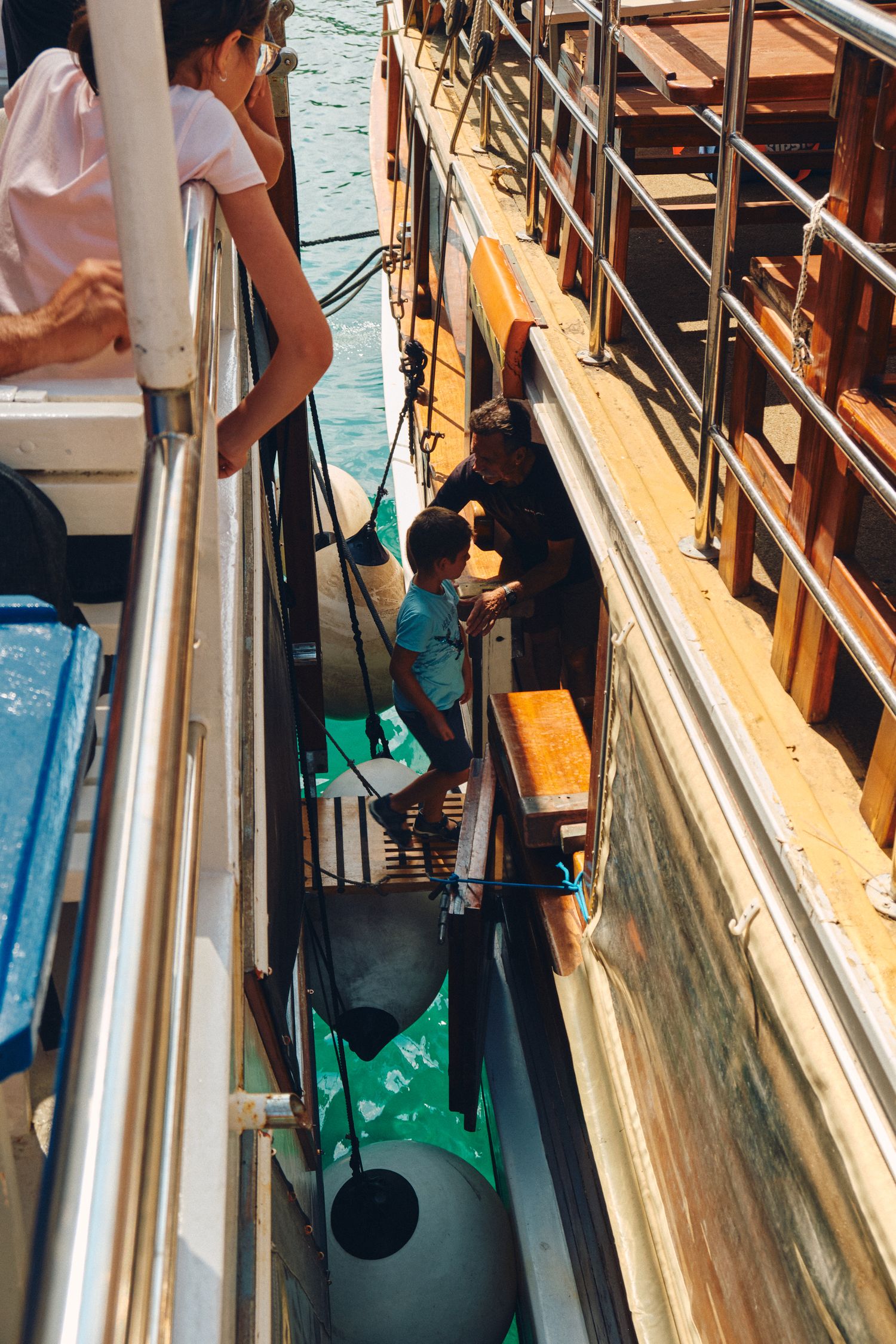 Narrow walkway along the side of a boat showing maritime equipment and deck details.
