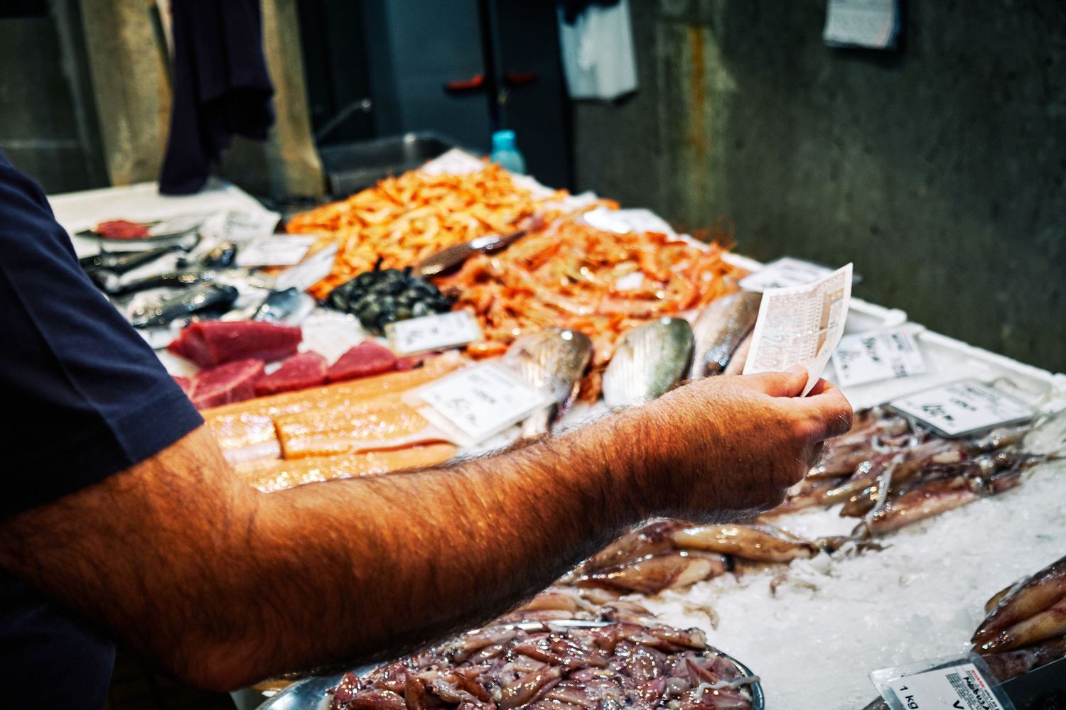 Fresh seafood and shellfish displayed on ice at a fish market counter.