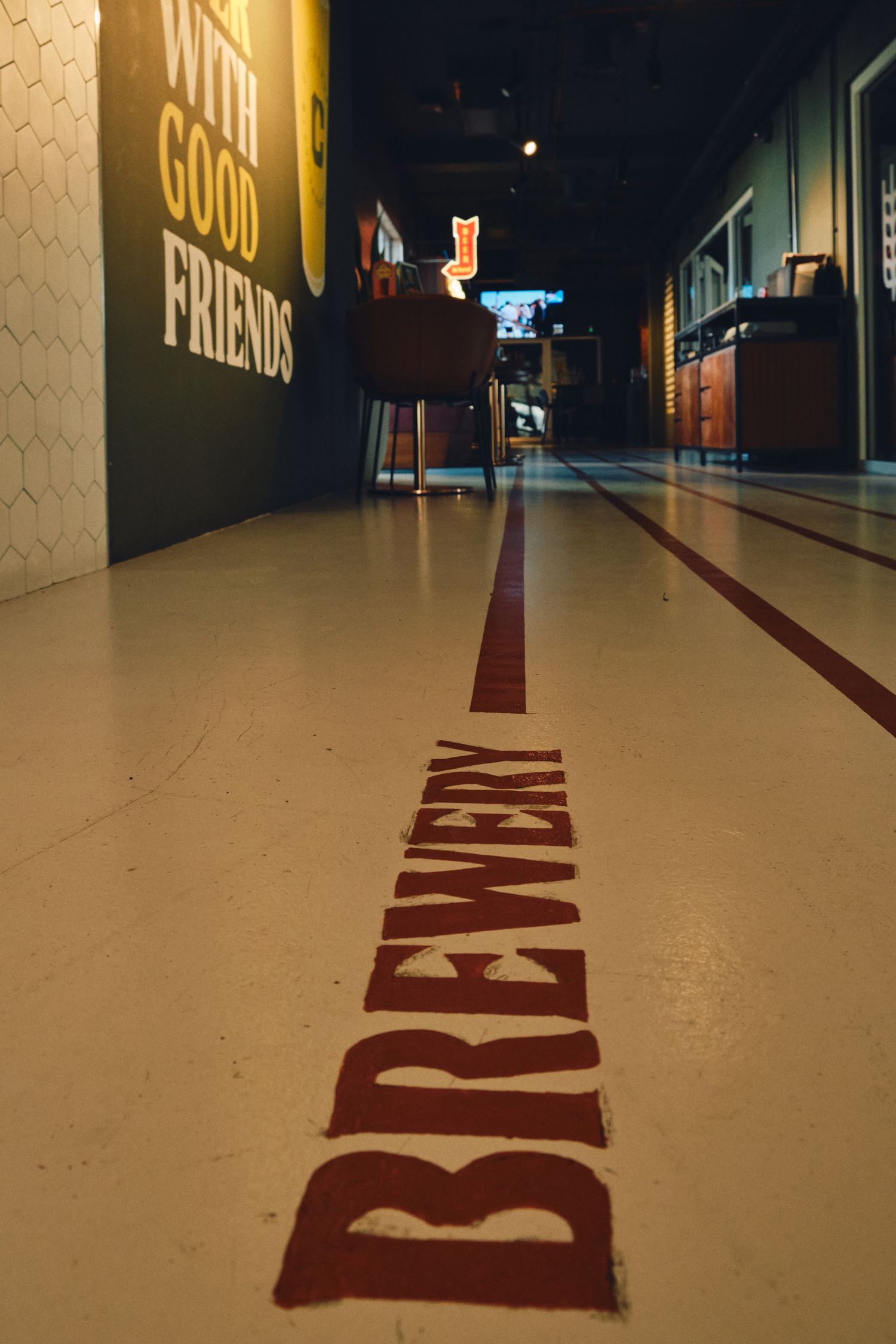 A brewery hallway floor with the word 'BREWERY' written in large red letters leading down a corridor.
