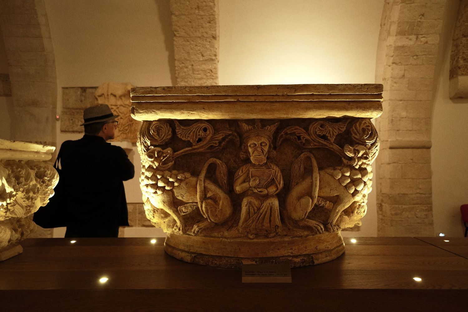 Illuminated ancient stone carving in a dimly lit cathedral interior.