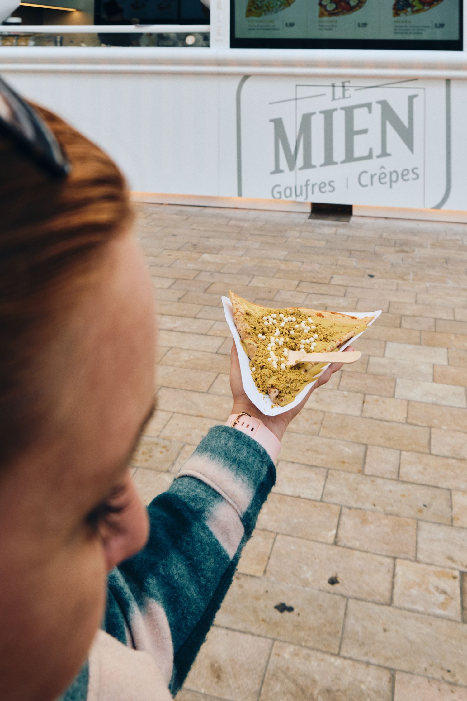 Close-up of a golden crepe being served at Le Mien food stand.