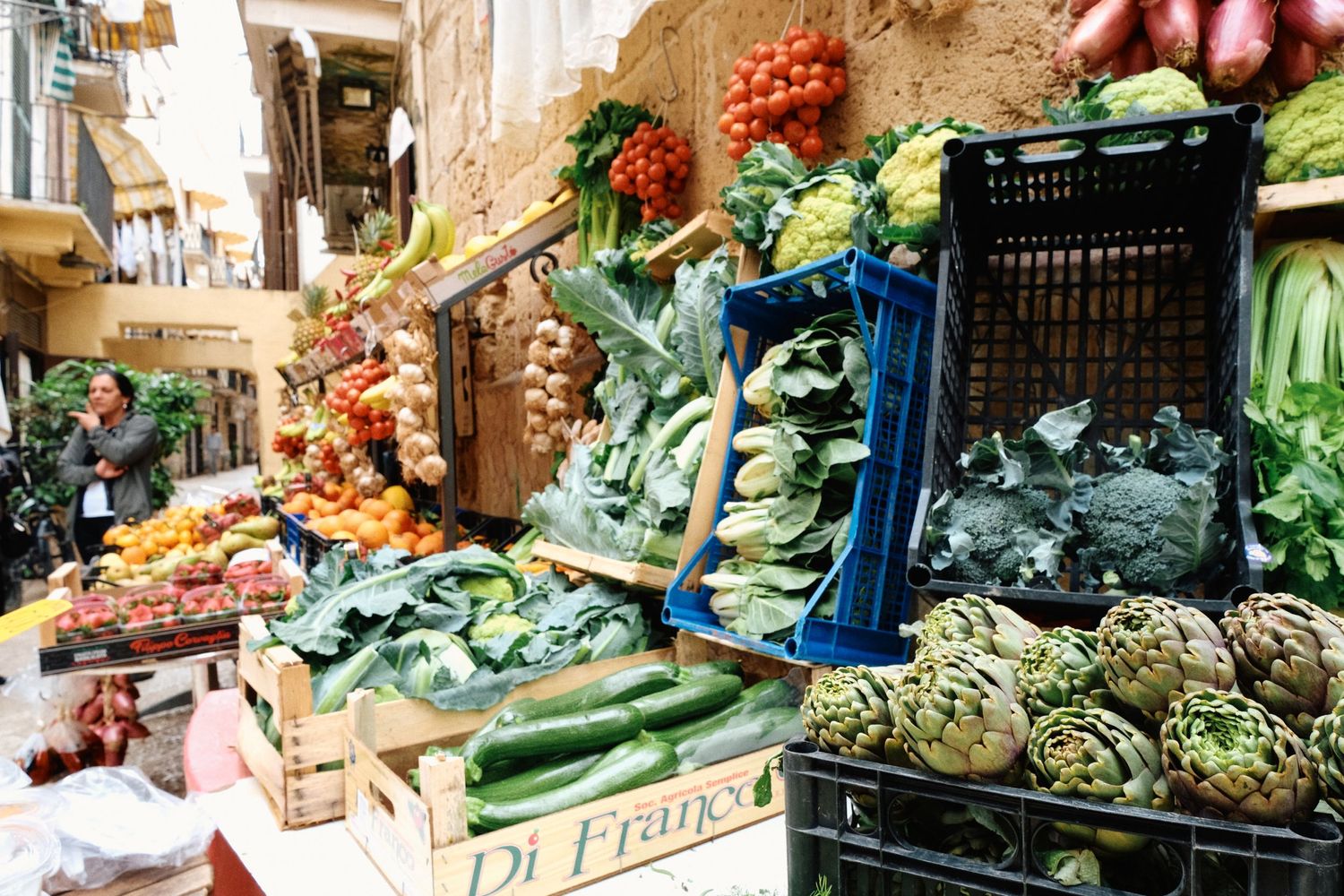 Colorful display of fresh vegetables and produce at Italian street market stall.