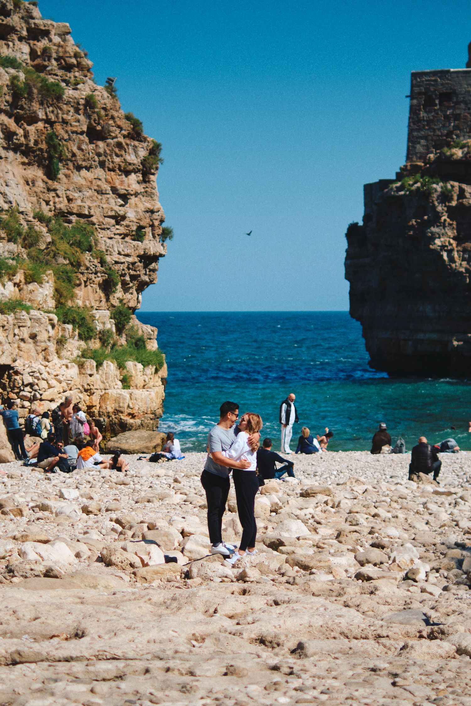 Rocky beach cove with limestone cliffs and crystal clear blue waters.