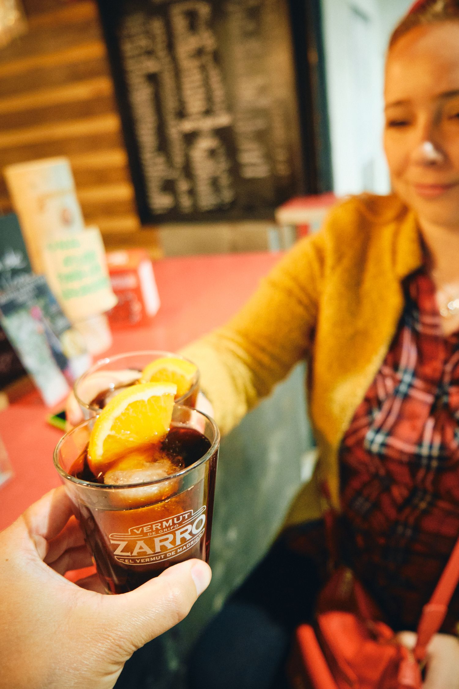 Sangria cocktail garnished with orange slices being served at a bar.