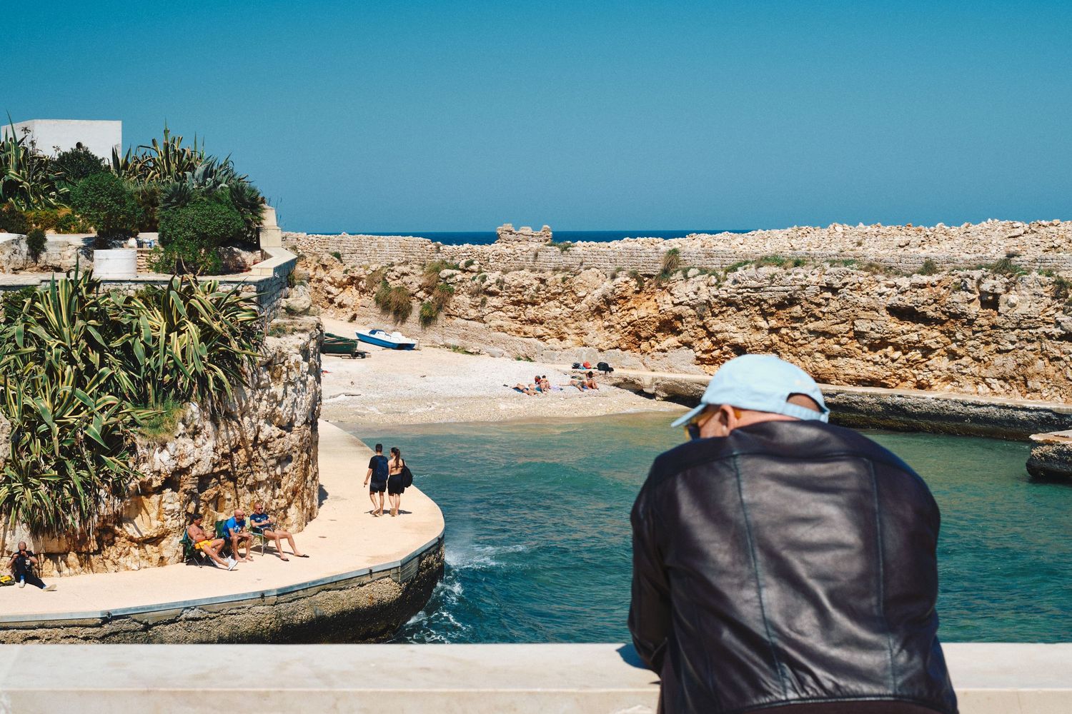Small rocky beach cove with crystal clear waters viewed from above.