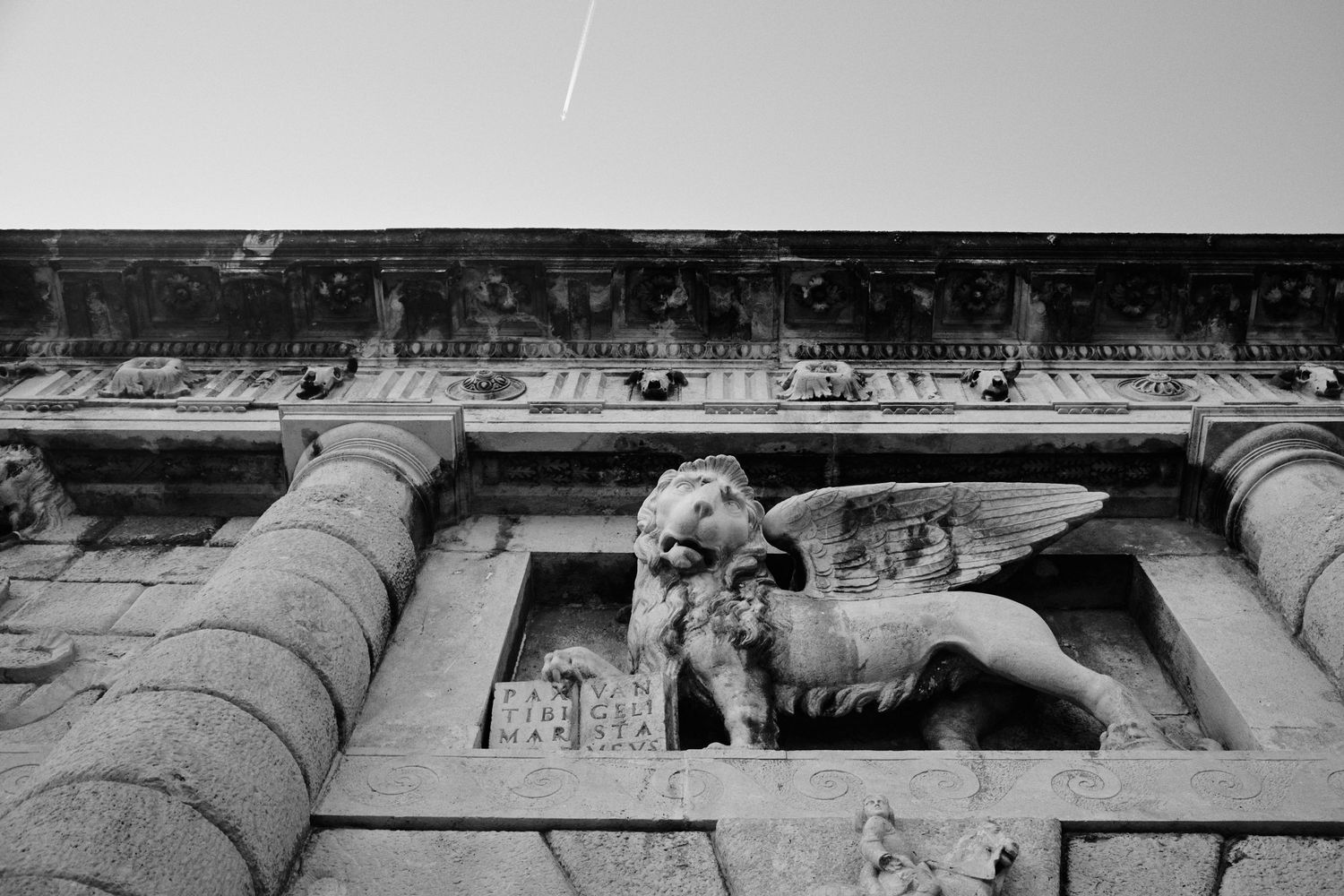 Ancient stone architectural detail showing decorative carved figure on historic building facade.