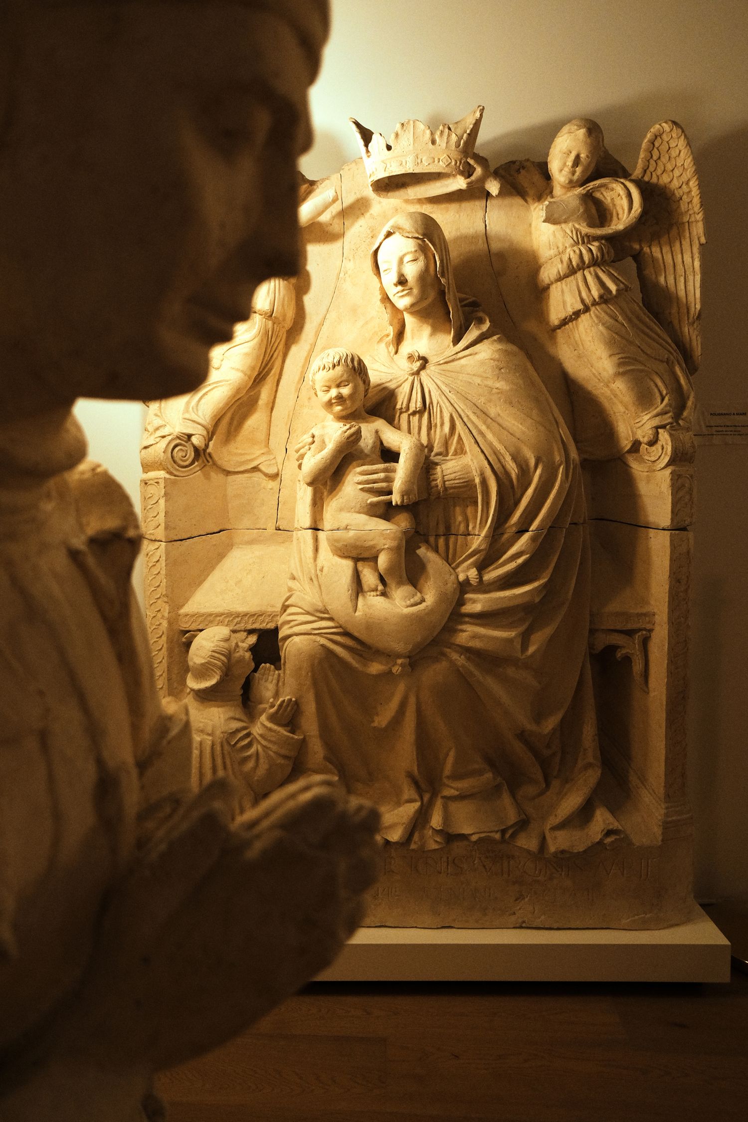Beautifully carved religious relief sculpture illuminated by warm lighting in a museum setting.