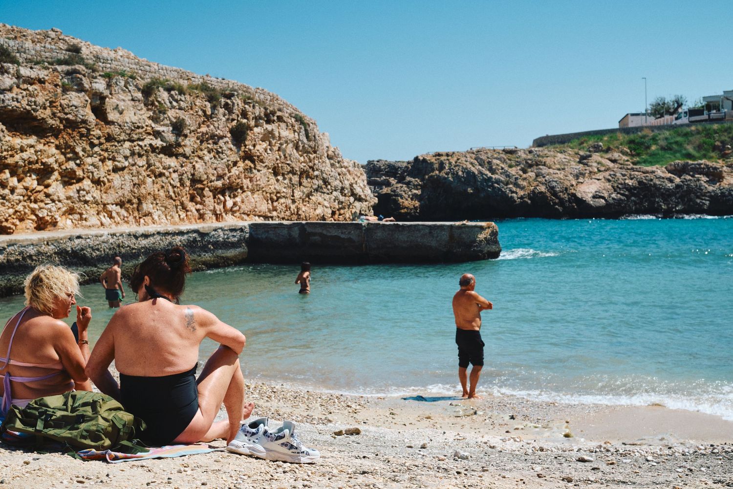 Beautiful secluded cove beach with turquoise water surrounded by limestone cliffs.